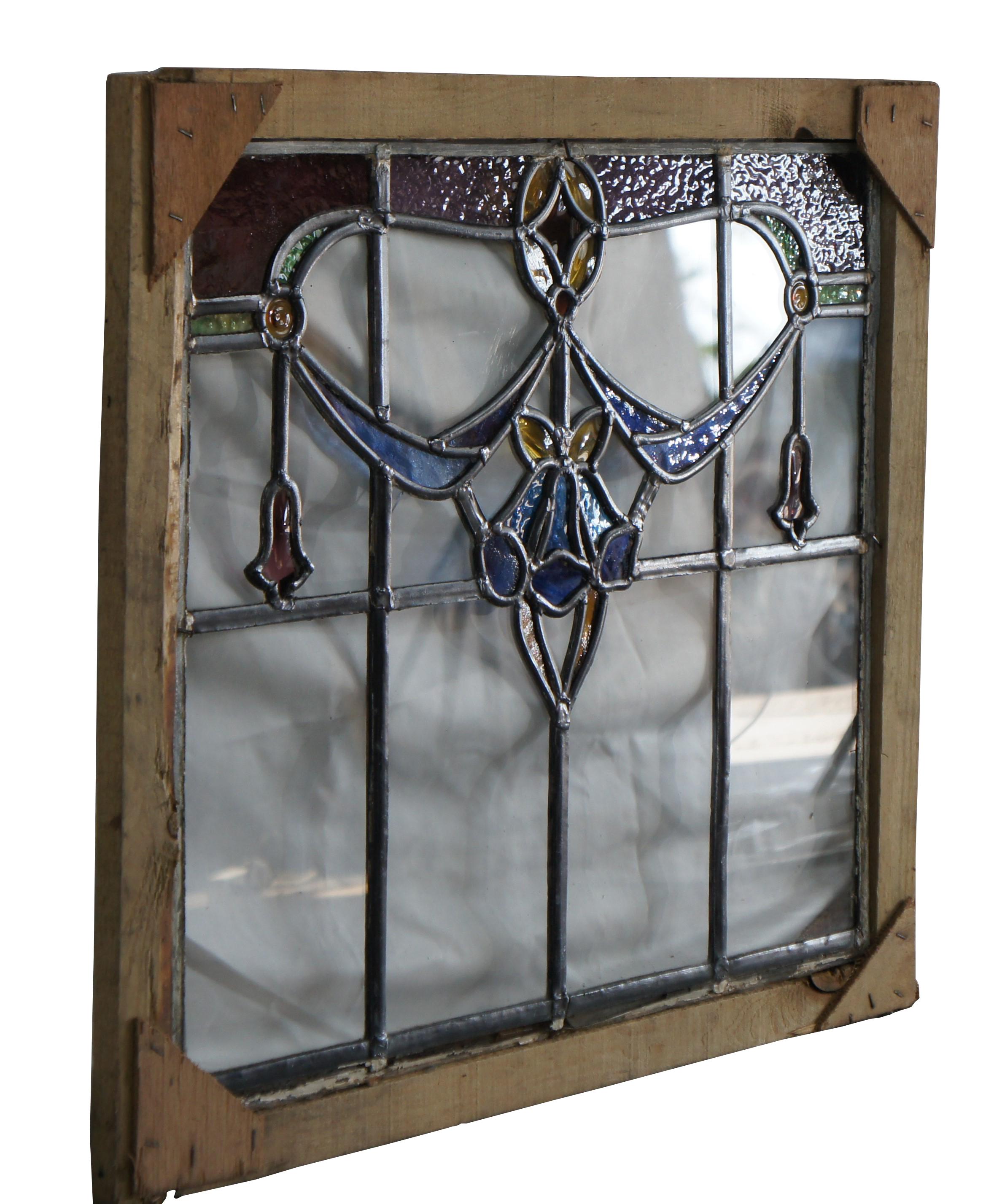 Exquisita vidriera emplomada antigua Art Nouveau.  Presenta guirnaldas florales en azul, ámbar, morado y verde sobre un fondo de paneles transparentes.   Enmarcado en madera para colgarlo fácilmente.  

Dimensiones:
26