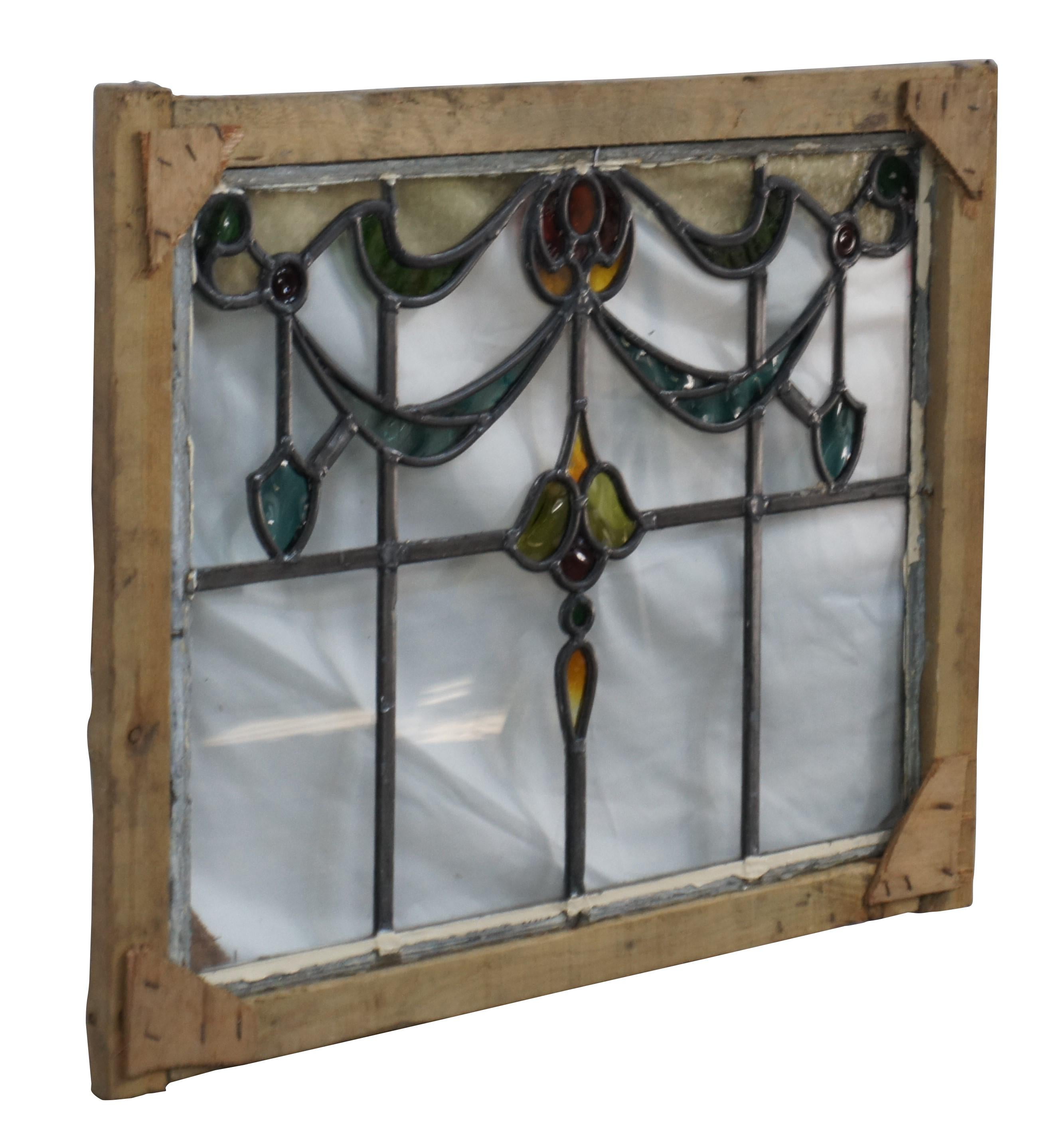 Exquisita vidriera emplomada antigua Art Nouveau.  Presenta guirnaldas florales en verde, ámbar y amarillo sobre un fondo de paneles transparentes.   Enmarcado en madera para colgarlo fácilmente.  

Dimensiones:
26