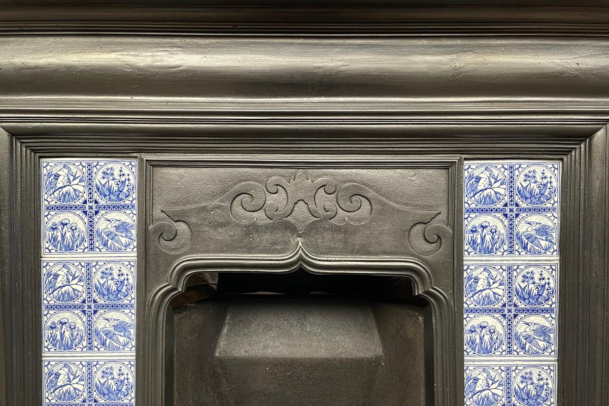 Reclaimed antique Victorian cast iron and tiled combination fireplace in the Arts & Crafts manner, produced by Thomas Elsley Ltd, London. Circa 1900. A simple cushion frieze sits above a bolection architectural moulding framing a set of original