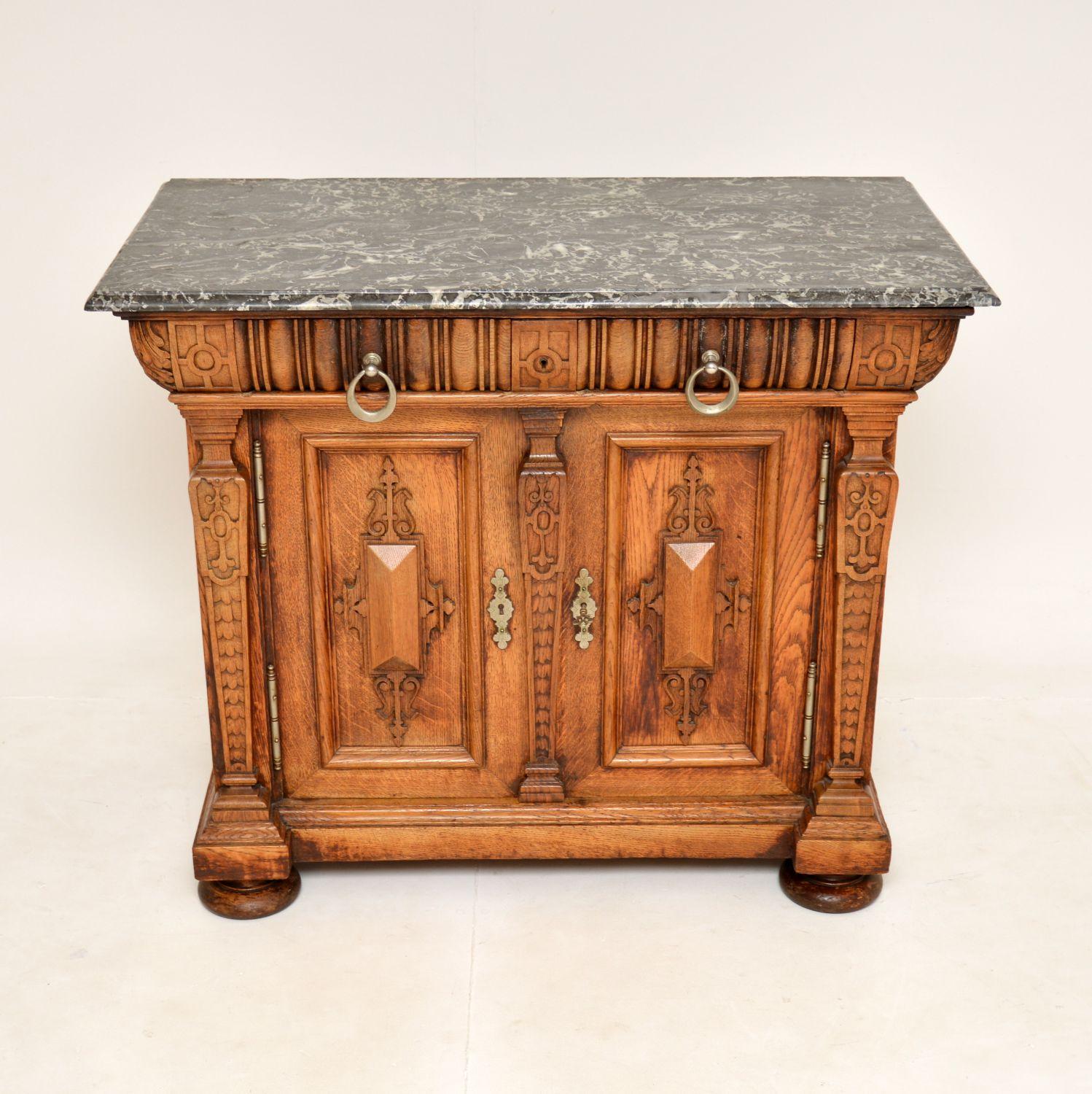 An amazing original antique Arts & Crafts period marble top carved solid oak cabinet. This was made in England, it dates from around the 1880-1890’s.

The quality is outstanding, with beautiful crisp carving, and very finely made brass hardware.