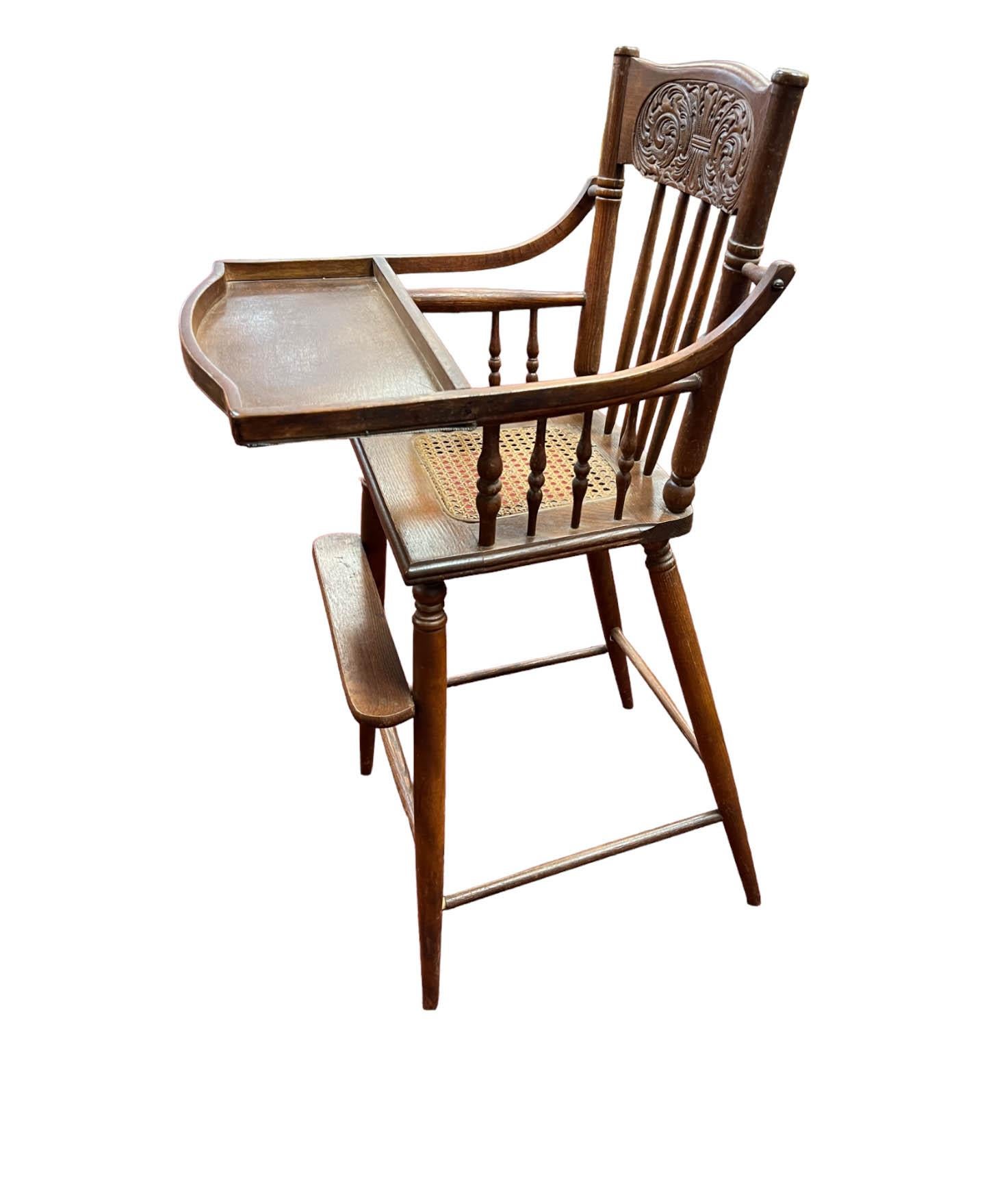 Chaise haute antique pour bébé de l'époque victorienne, une pièce charmante et authentique qui rappelle une époque révolue. Cette chaise haute présente de nombreux détails exquis, tels que l'assise en rotin, le dossier sculpté de manière complexe et