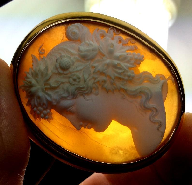 Museum quality cameo depicting a Bacchante. This one is a spectacular cameo very finely carved, she's so feminine and full of grace. Look at how the carver used the shell to give three-dimensionality to her cheek, to the grapes and to her hair, look
