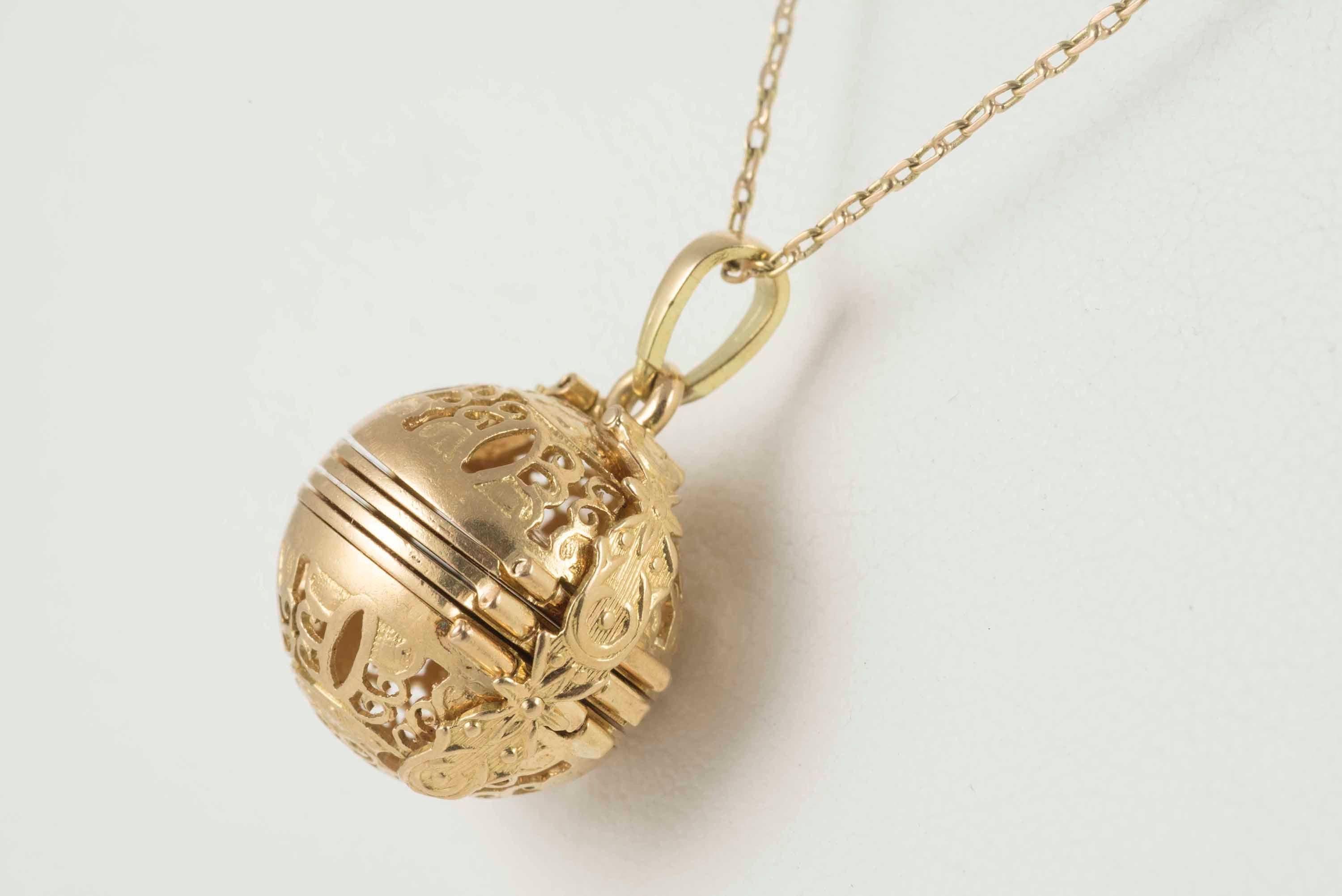 Crafted in the 1880s, this exquisite Victorian ball pendant decoratively pierced and hand fashioned in 14-18kt yellow gold opens to reveal six locket compartments. The chain measures 18 inches long. 