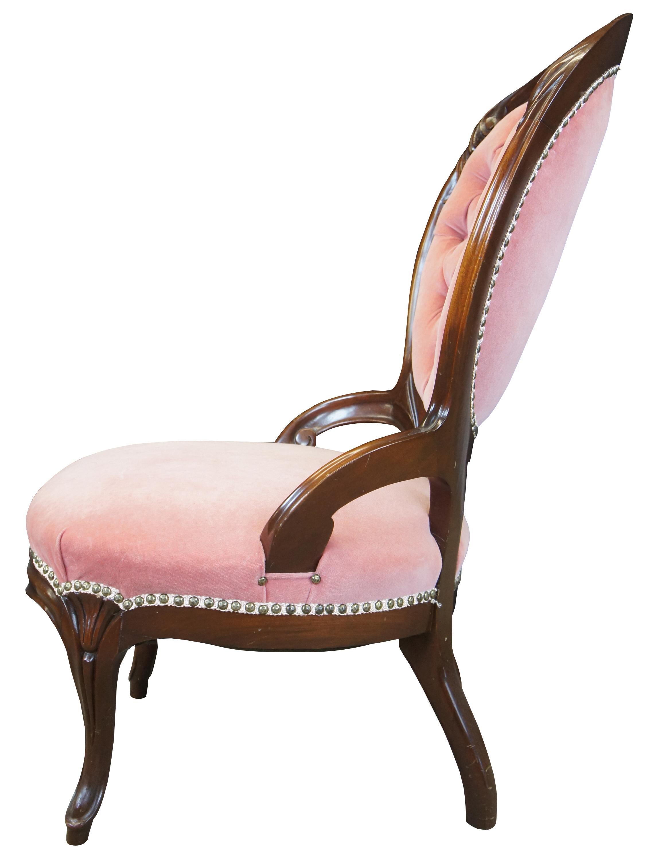Antique Victorian side accent vanity or parlor chair. Made of walnut featuring serpentine form with pink velvet upholstery, tufted balloon back, and nailhead trim.
     