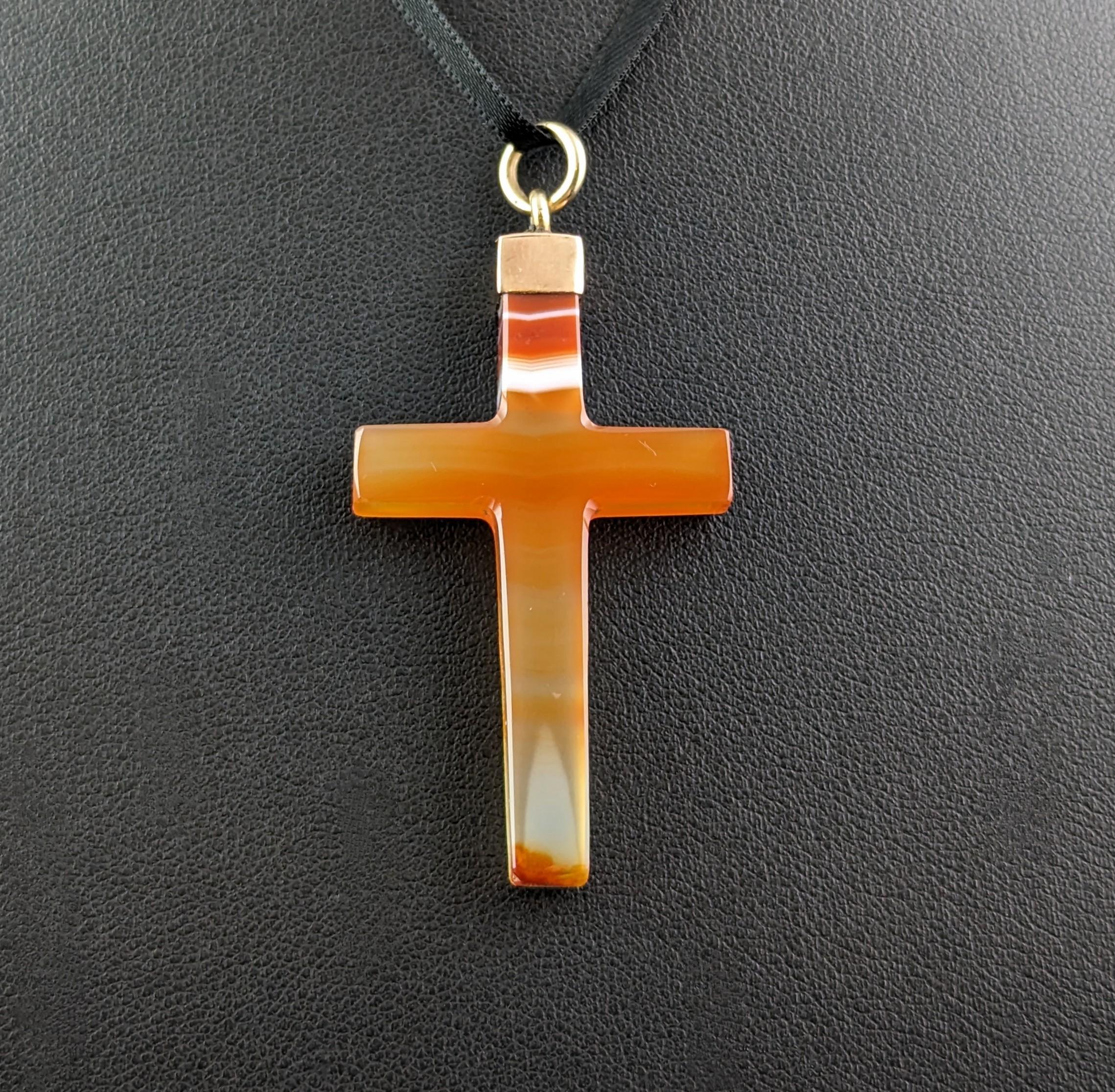 A gorgeous antique banded agate cross pendant.

It is a lovely orange toned agate with both clear and white stripes running through it.

The Cross has a 9ct gold cap and bale to the top of the cross ready to hang fro your favourite antique gold