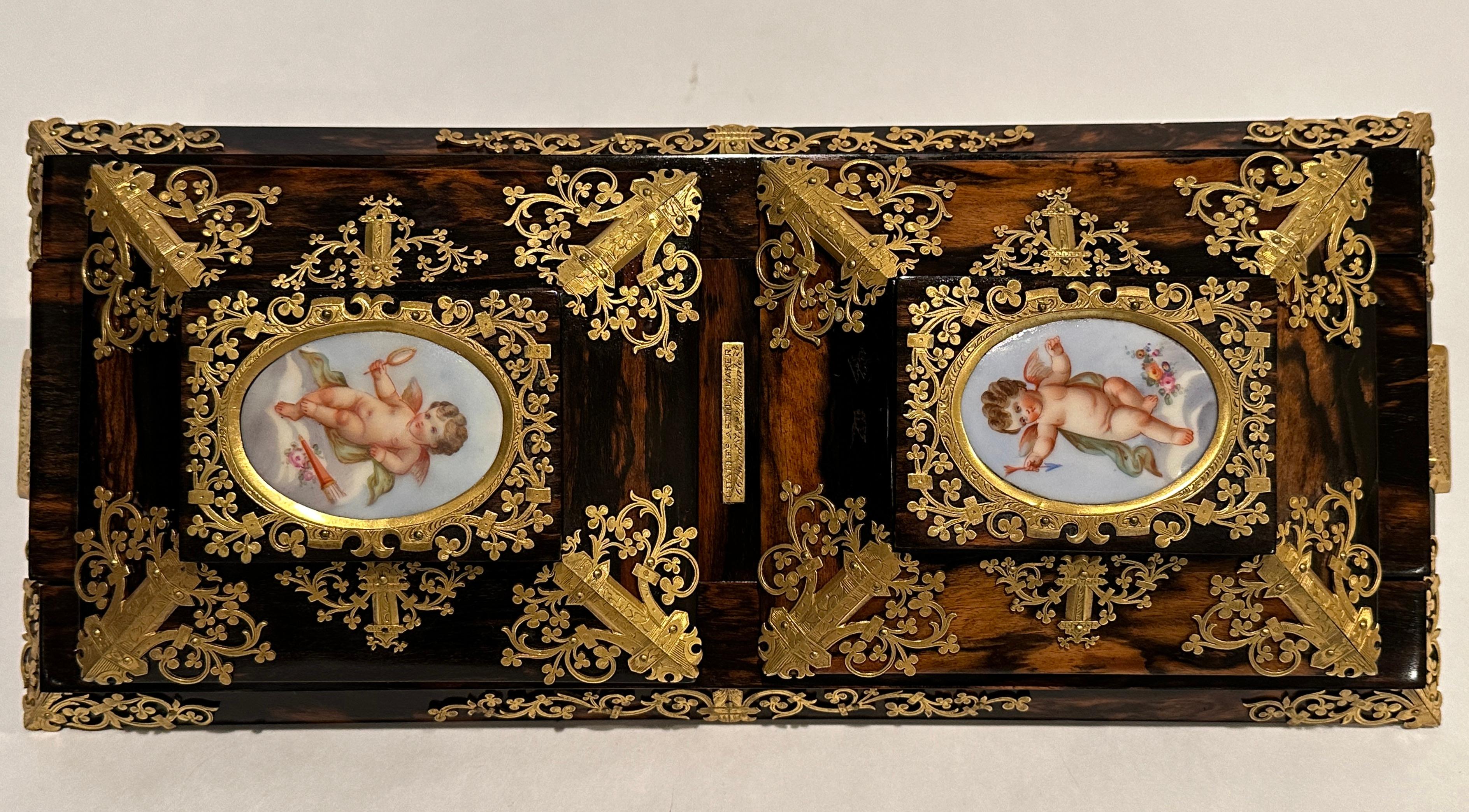 This is a high quality antique Victorian Coromandel self closing adjustable book slide, circa 1860 in date.

It features a pair of oval Sevres style plaques depicting cherubs at play and it is wonderfully decorated with stupendous gilt bronze