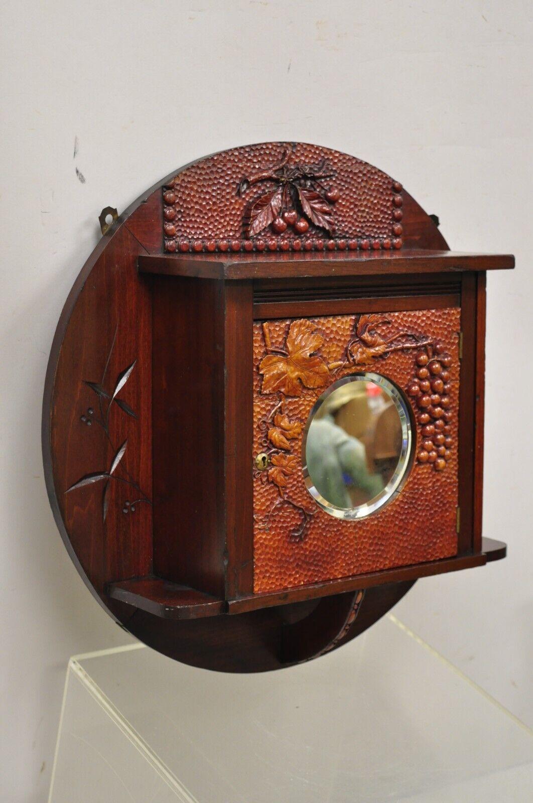 Antique Victorian black forest carved round wall mirrror curio cabinet. Item features round beveled glass central mirror, carved 