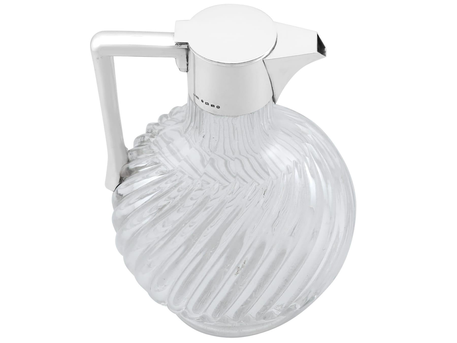 An exceptional, fine and impressive antique Victorian sterling silver and blown glass claret jug; an addition to our antique glassware collection.

This fine antique Victorian sterling silver and blown glass claret jug has an oval rounded form.

The