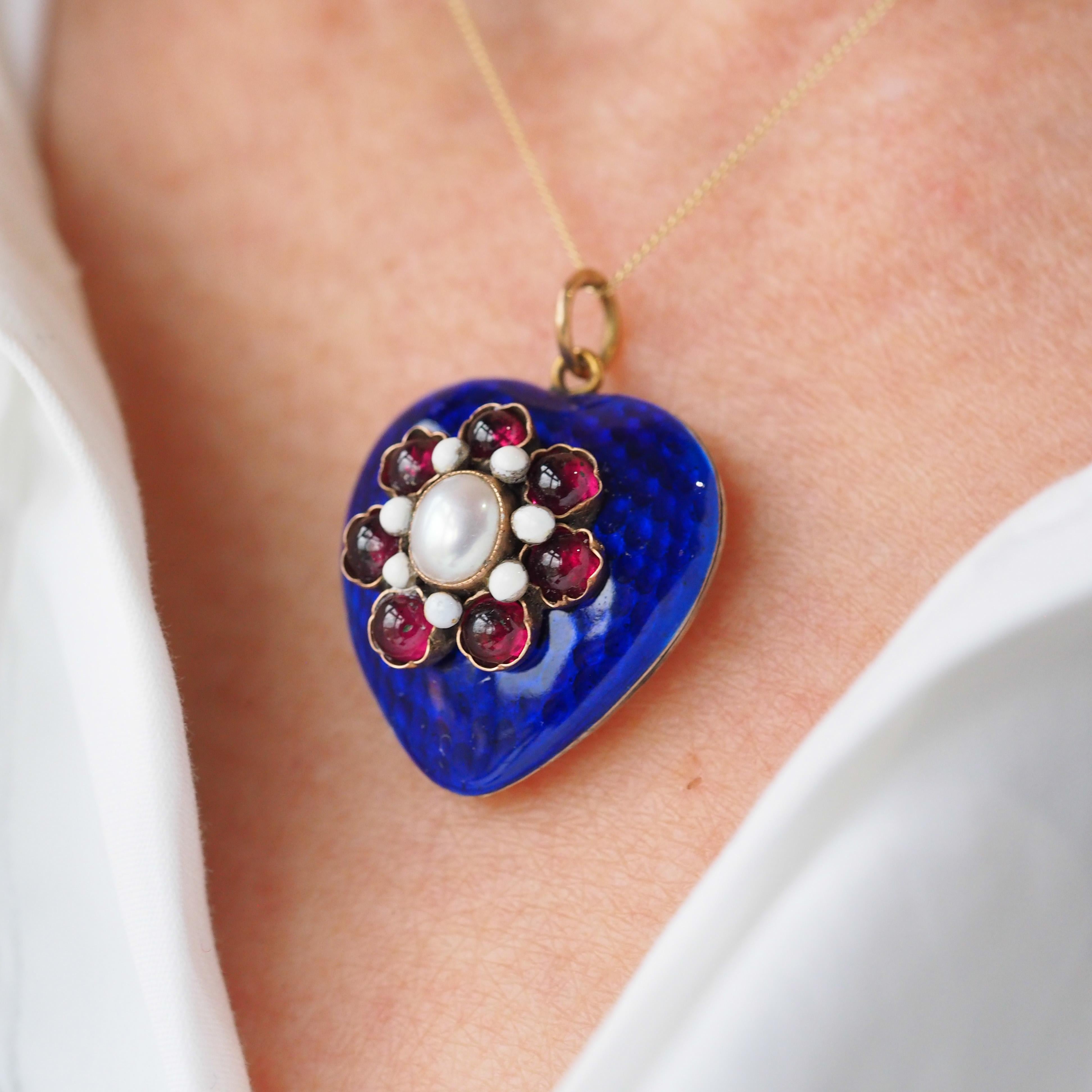 We are delighted to offer this adorable antique Victorian silver-gilt heart pendant made c.1900.
  
Captivating and enchanting upon first glance, this pendant features a rich royal blue coloured enamel on top of a textured (almost strawberry-like)