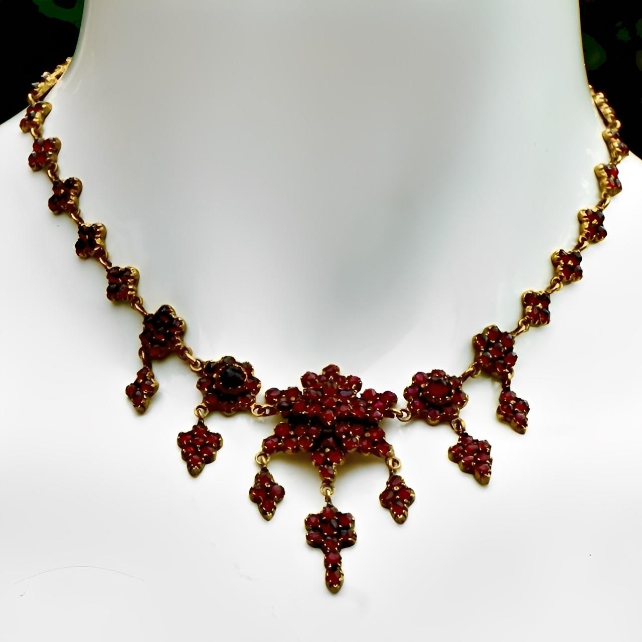 Magnifique collier victorien serti de grenats de Bohême facettés. Les grenats sont sertis dans de l'or à faible carat, avec de jolies fleurs et gouttes de grenat, et un grand grenat central. 

Le collier est plus court et mesure 37,3 cm / 14,7