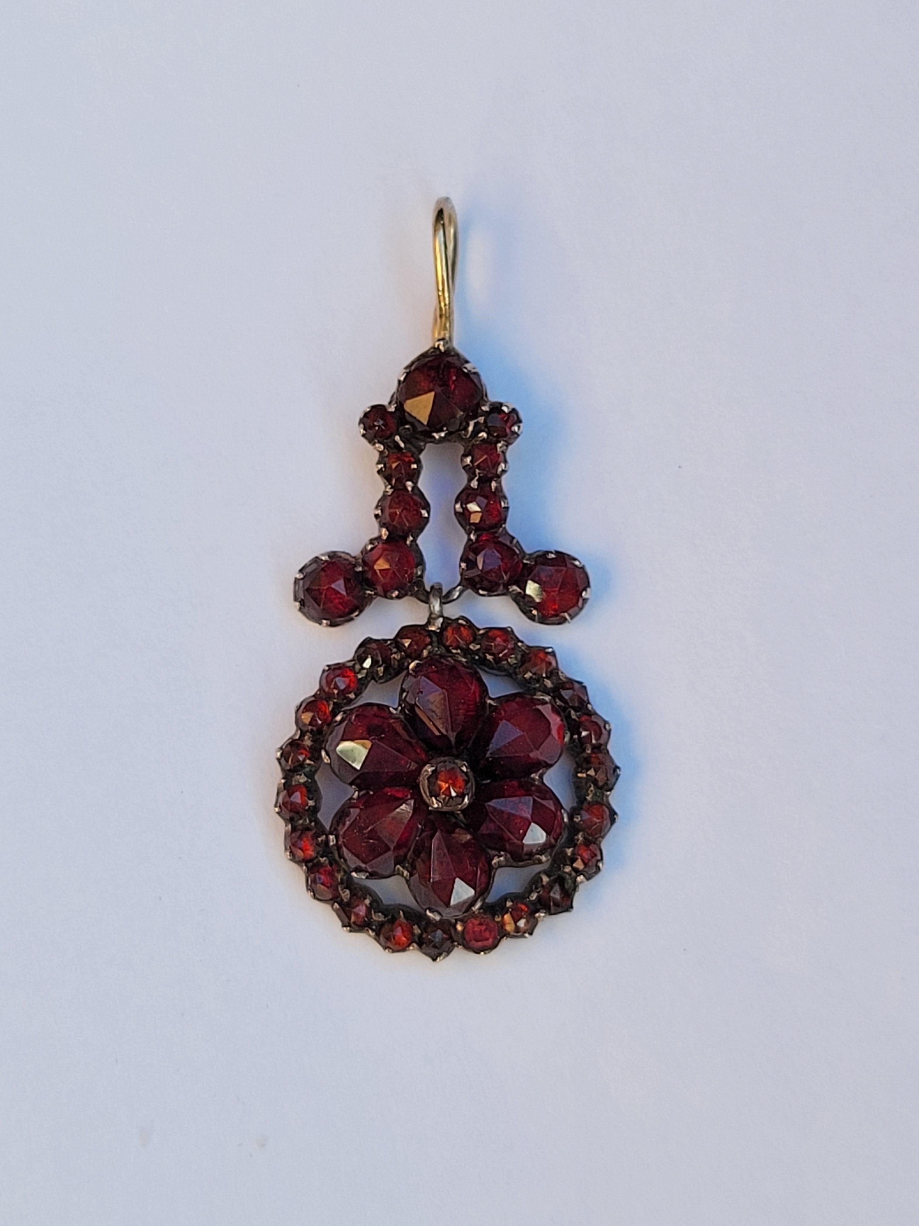 A lovely antique Victorian (c. 1890) rose-cut Bohemian garnet flower pendant. The pendant is complete with a late gold bale and perfect as an everyday or special occasion piece of jewelry.

Garnet stone of passionate love and friendship, also