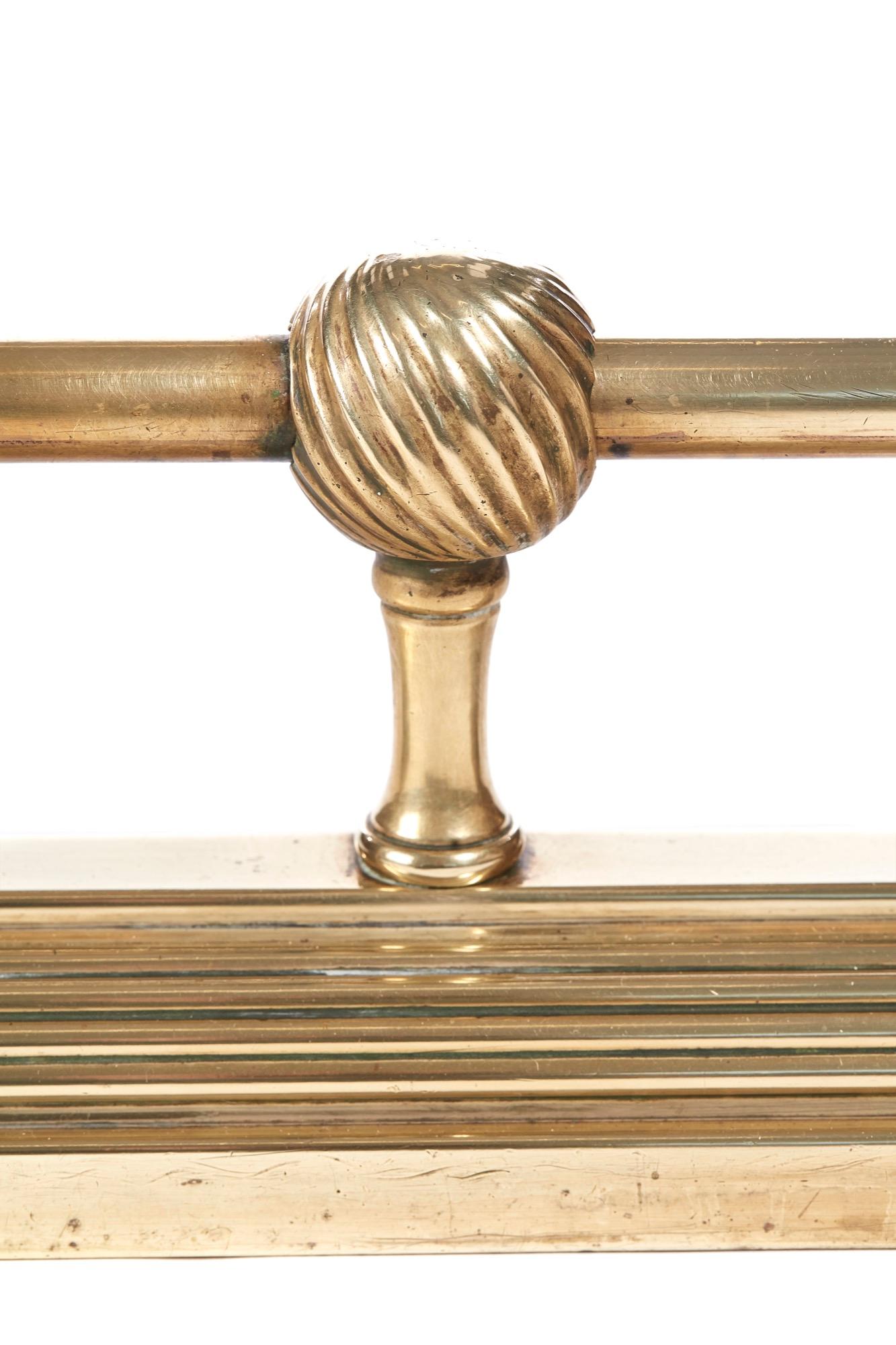 Antique Victorian brass fender having top round brass rail supported by 6 round reeded brass balls with column supports, standing on a shaped bass.
Lovely color and condition.
Measures: 54