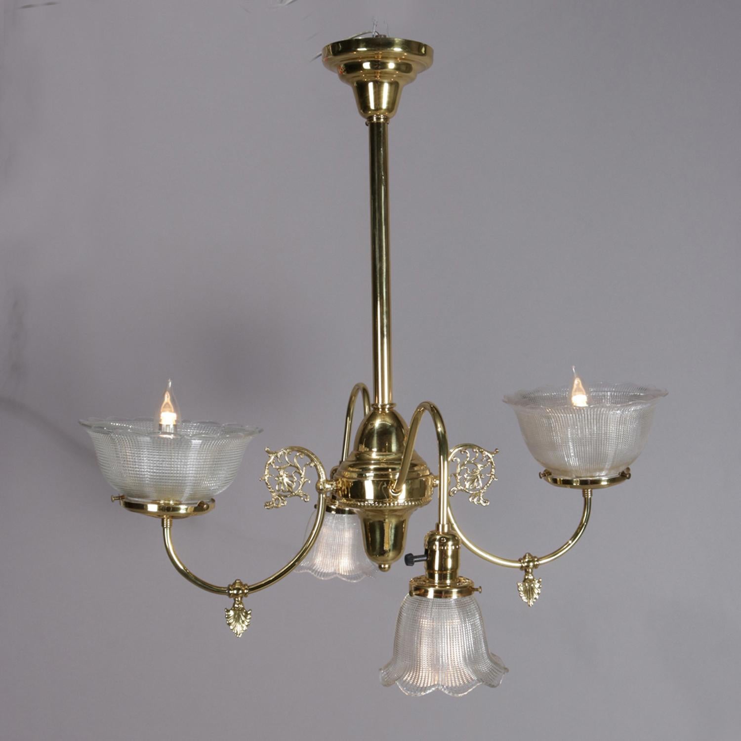 Antique Victorian gas conversion style Up and Down hanging light fixture features brass frame with four C-scroll and foliate arm terminating in pressed glass shades, independently controlled lights, circa 1900

Measures: 27