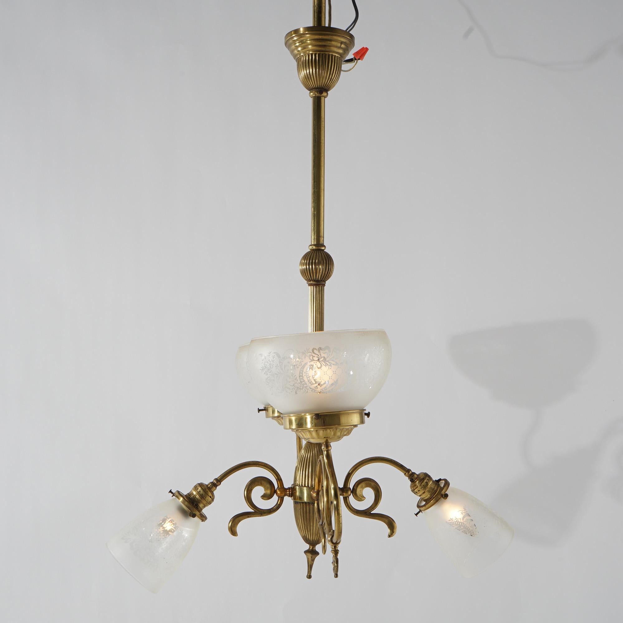An antique Victorian up-and-down electric and gas chandelier offers brass frame with two up-lights and two down-lights, each terminating in glass shades, 19th century

Measures - 34.5