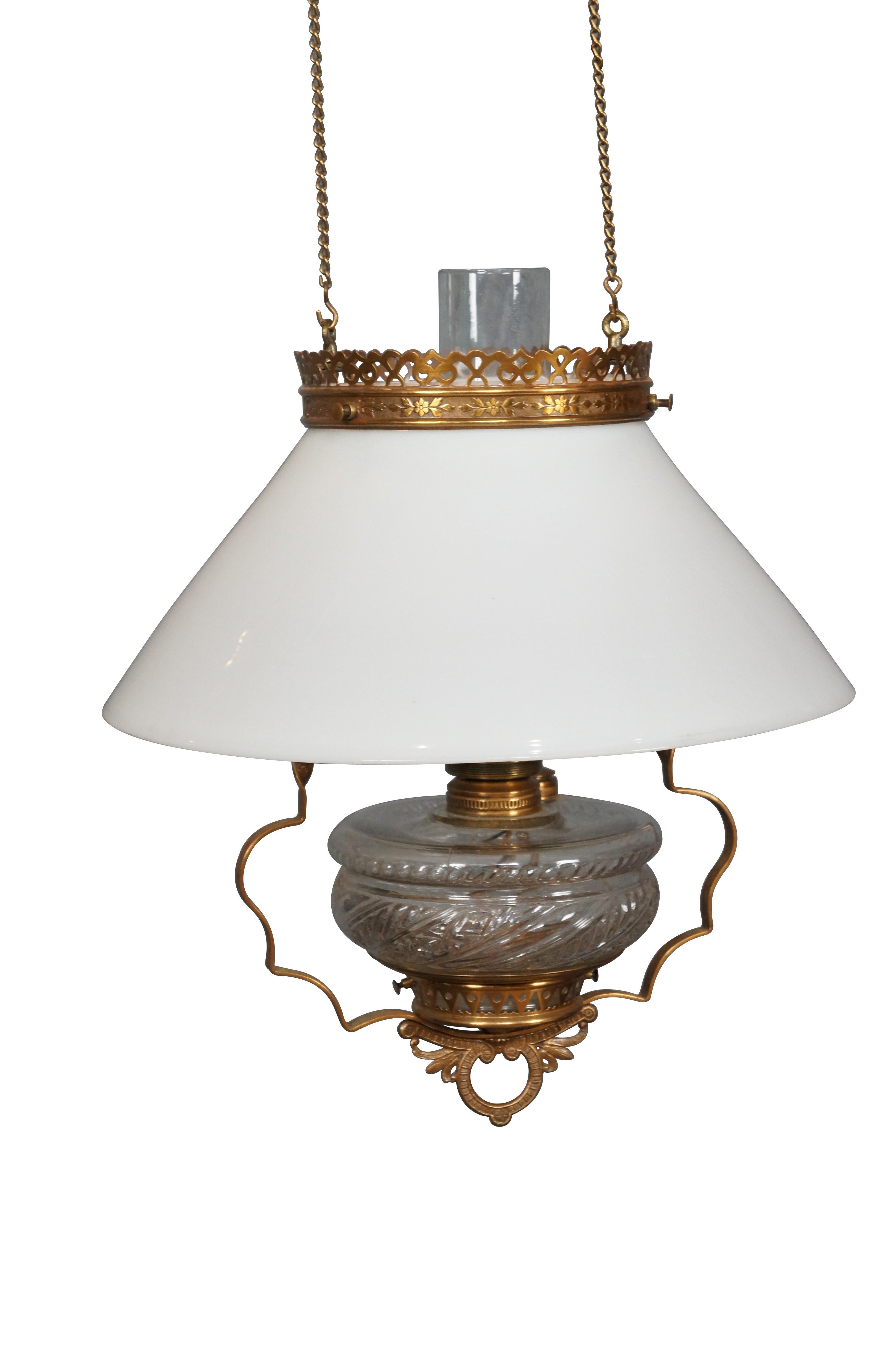 Antique late 19th century Aesthetic Movement cieling mounted parlor light / chandelier featuring pierced brass design with pressed glass oil reservoir, milk glass shade, clear hurricane and brass smoke bell. Suspends from cieling mount with two