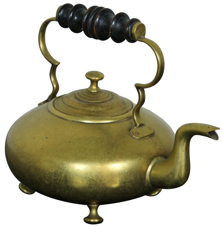 Antique Victorian era brass hot toddy kettle with low round body, classic goose neck spout, turned wood handle and standing on four rounded feet. Measure: 10