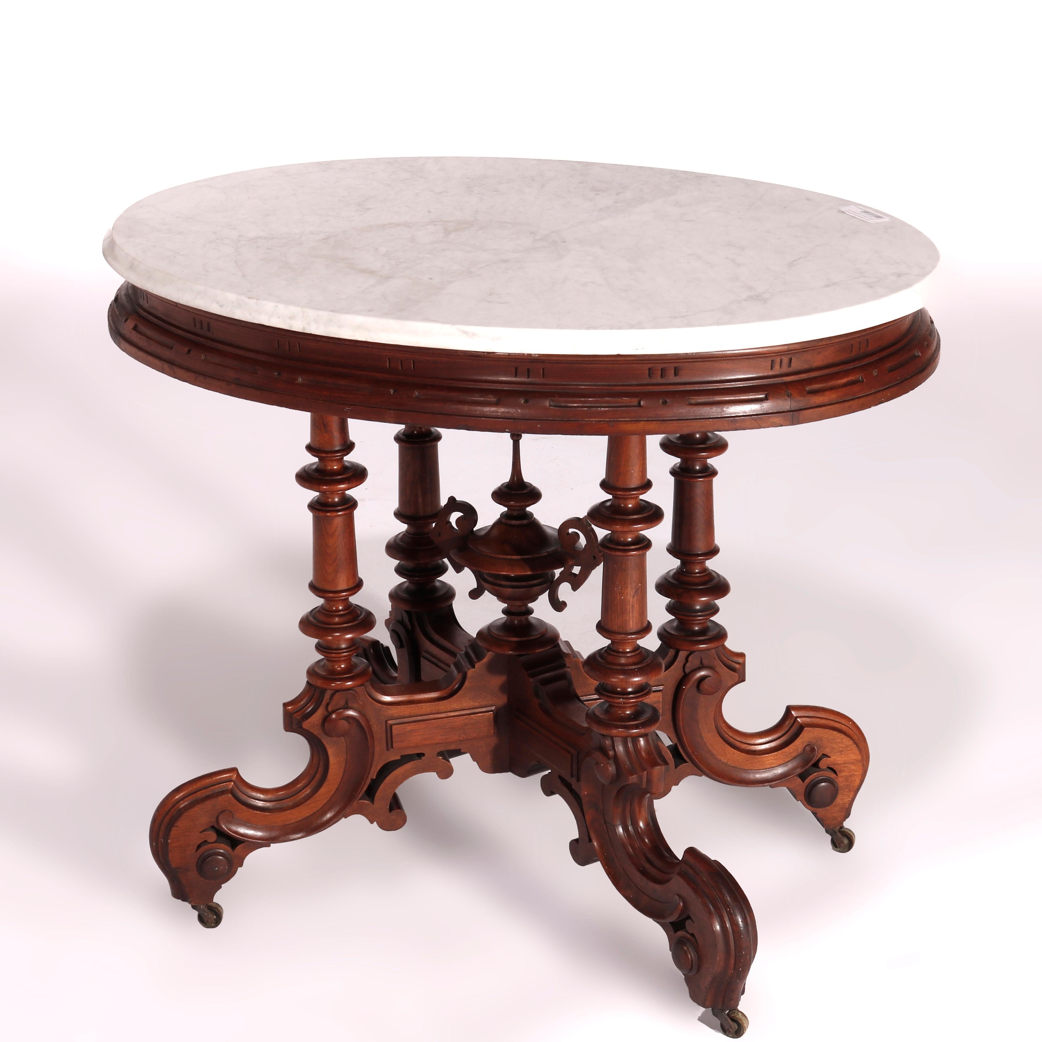 An antique Victorian Brooks Brothers parlor table offers beveled marble top over walnut base with four turned supports surrounding central carved urn form final, raised on scroll form legs, circa 1890

Measures - 31.5