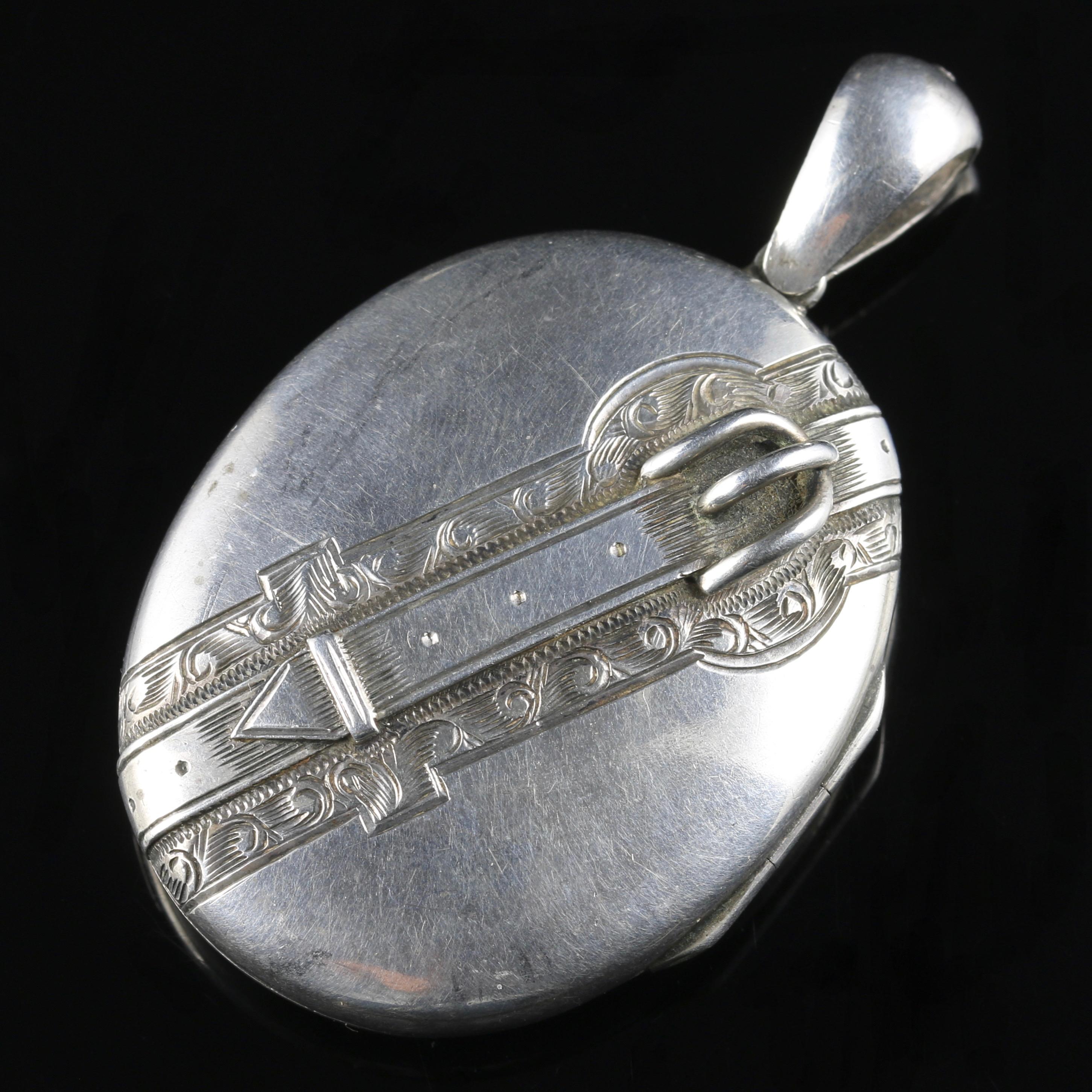 For more details please click continue reading down below...

This fabulous antique Victorian locket is all Sterling Silver, Circa 1870.

A lovely engraved large locket that depicts a buckle diagonally strapped across the front with beautiful