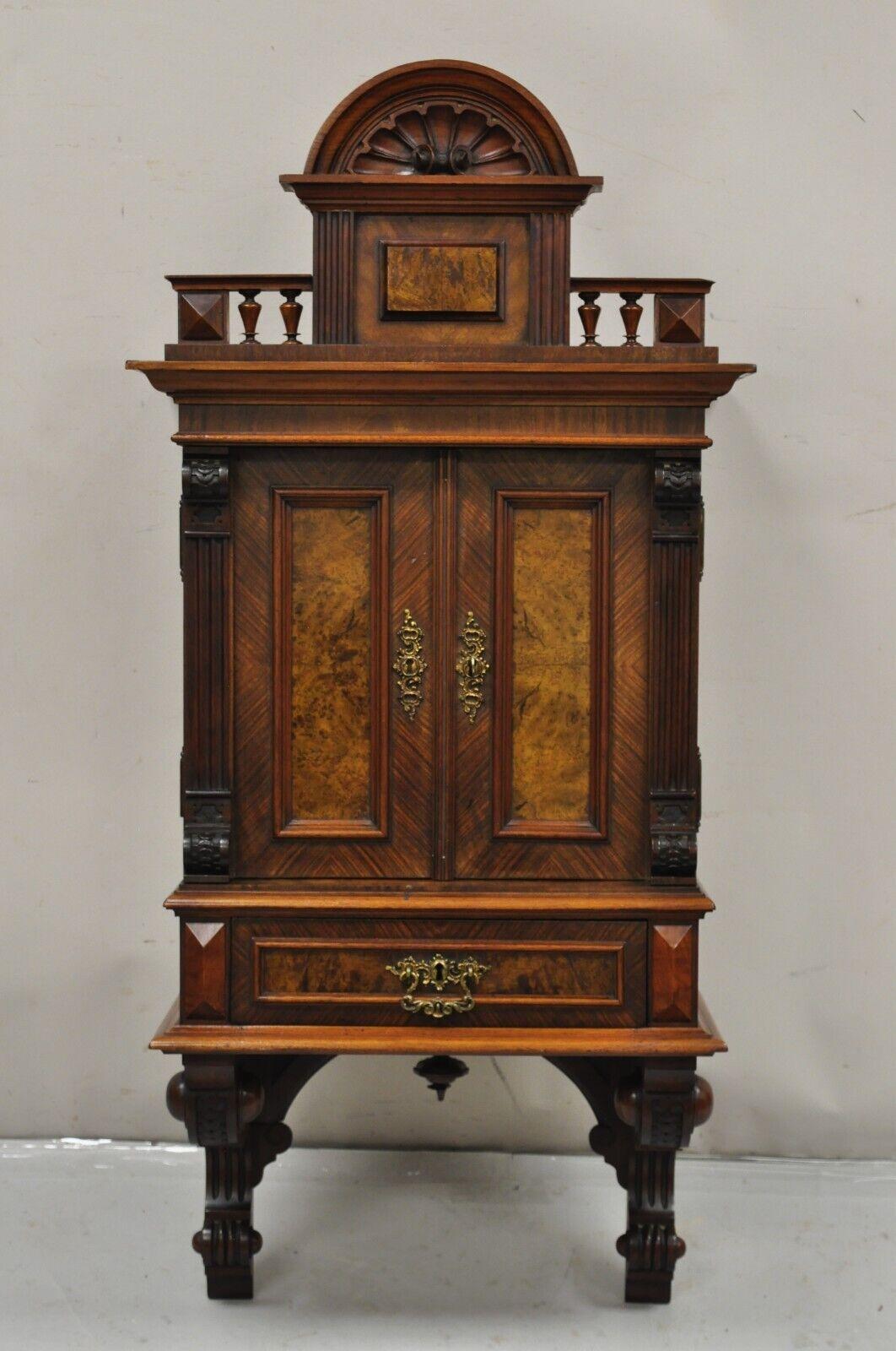 Antique Victorian Burled Walnut Shell Carved Wall Hanging Curio Display Cabinet. Item features one dovetailed drawer, working lock and key, 2 wooden shelves, beautiful wood grain, nicely carved details. Circa 19th Century. Measurements: 46