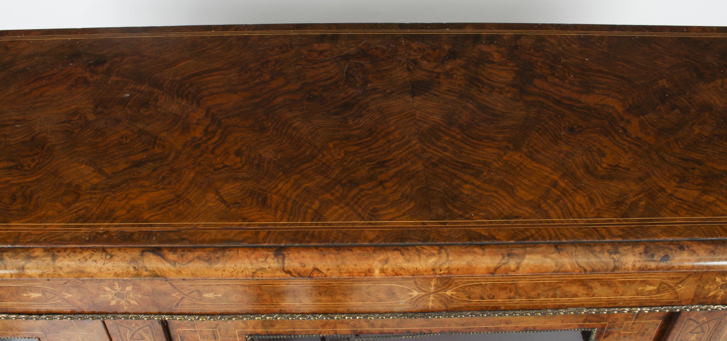 This is a lovely antique Victorian burr walnut, marquetry inlaid and ormolu mounted credenza / bookcase, circa 1860 in date.
 
The credenza features a moulded shaped top above three glazed doors and it features decorative wood crossbanding with