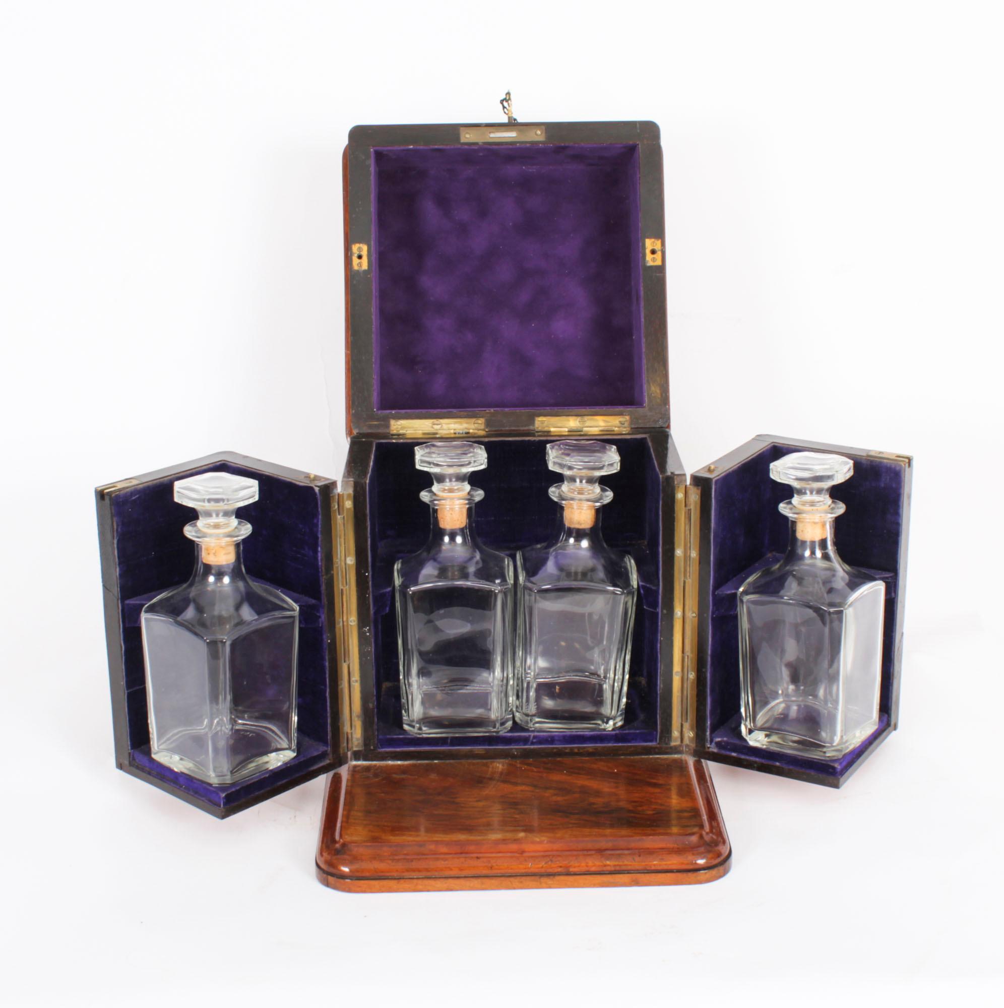 This is a superb antique Victorian burr walnut cased four decanter tantalus, circa 1870 in date.

It was skillfully crafted in beautiful burr walnut with cut brass mounts to the hinged lid, a swing out compartment either side and standing on a