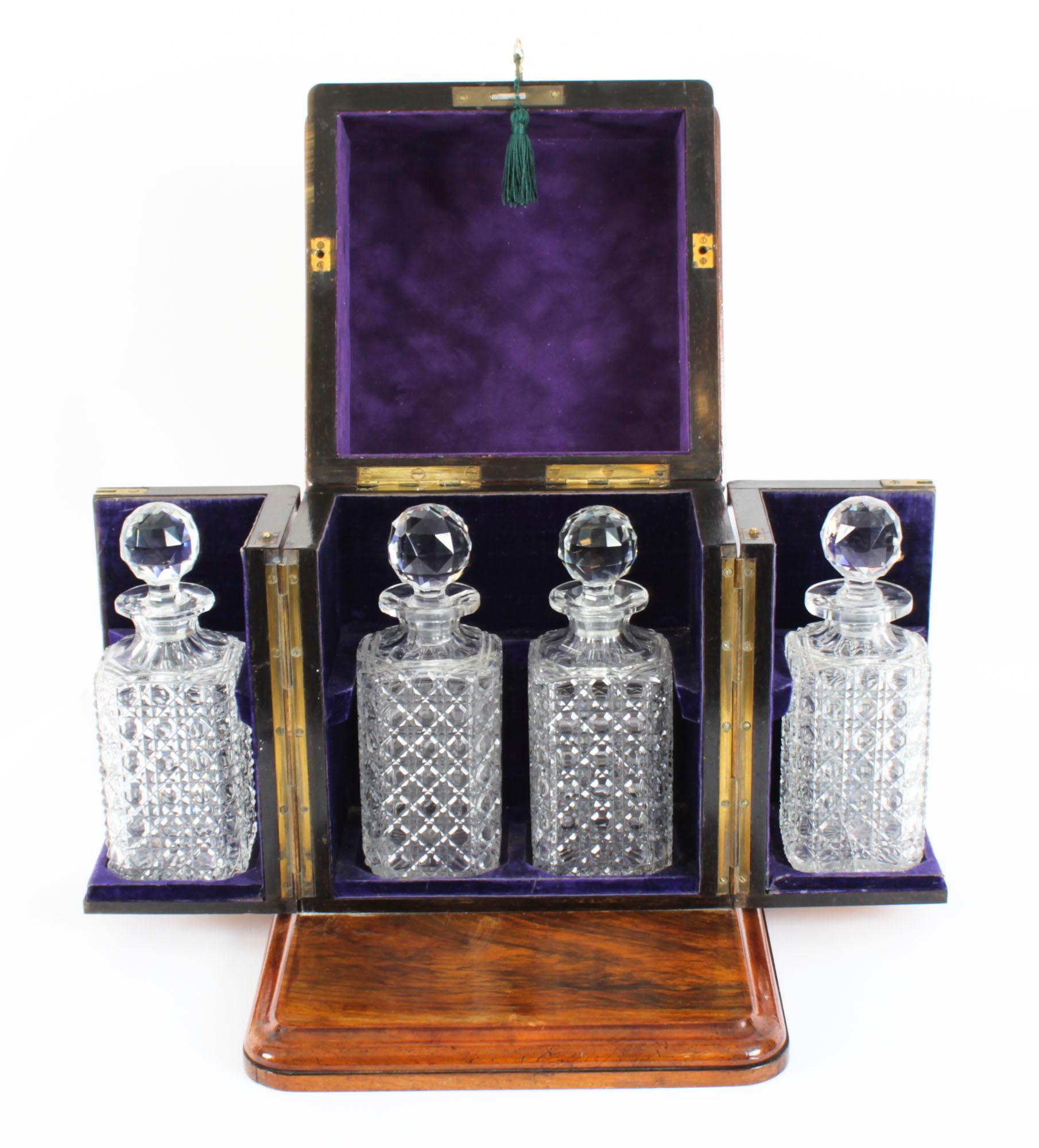This is a superb antique Victorian burr walnut cased four decanter tantalus, circa 1870 in date.

It was skillfully crafted in beautiful burr walnut with cut brass mounts to the hinged lid, a swing out compartment either side and standing on a