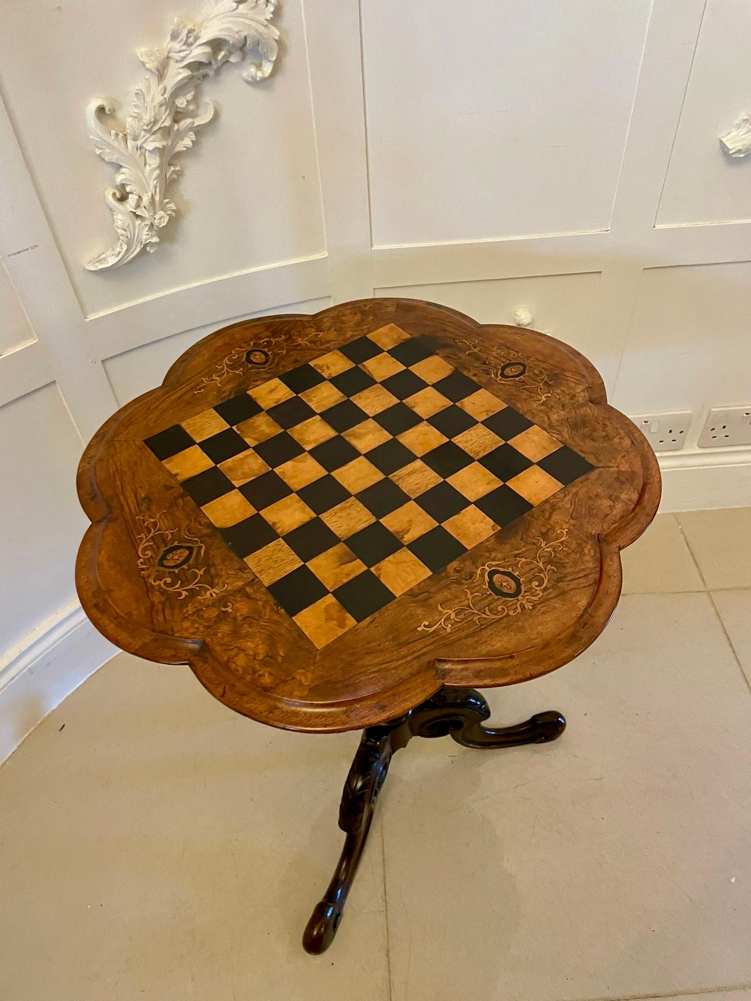 Table d'échecs victorienne en ronce de noyer et marqueterie, de forme élégante et festonnée. Le plateau en noyer magnifiquement figuré présente un échiquier central incrusté de carrés alternant des placages de bois satiné et de bois ébonisé, bordés