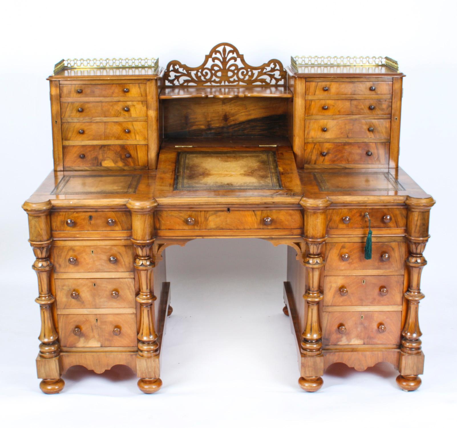 This is a truly superb antique Victorian Period burr walnut Dickens pedestal desk, circa 1880 in date.

The sunken central superstructure is flanked on either side by columns of five drawers centred by a gallery shelf above a hinged surface