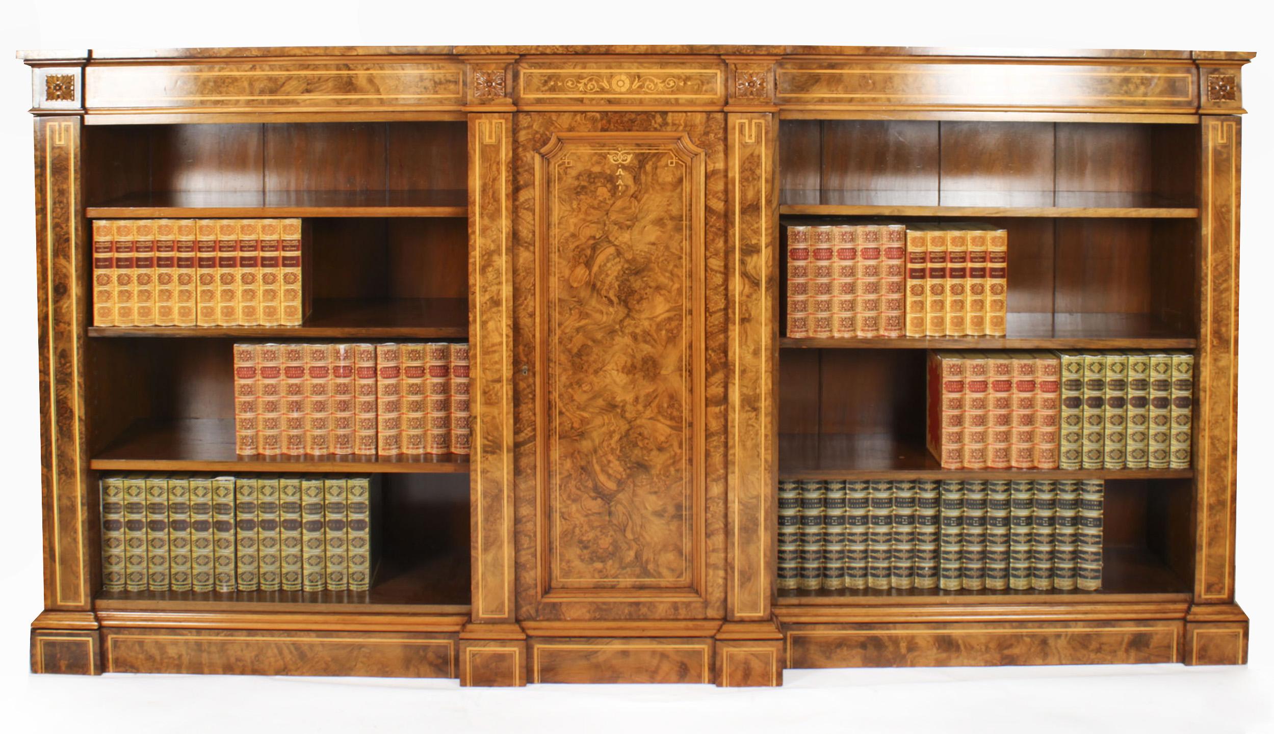 This is a superb antique Victorian burr walnut and marquetry inlaid breakfront open bookcase, circa 1860 in date.
 
The bookcase features beautiful satinwood crossbanding and four carved anthemion plaques, the breakfront central cupboard door