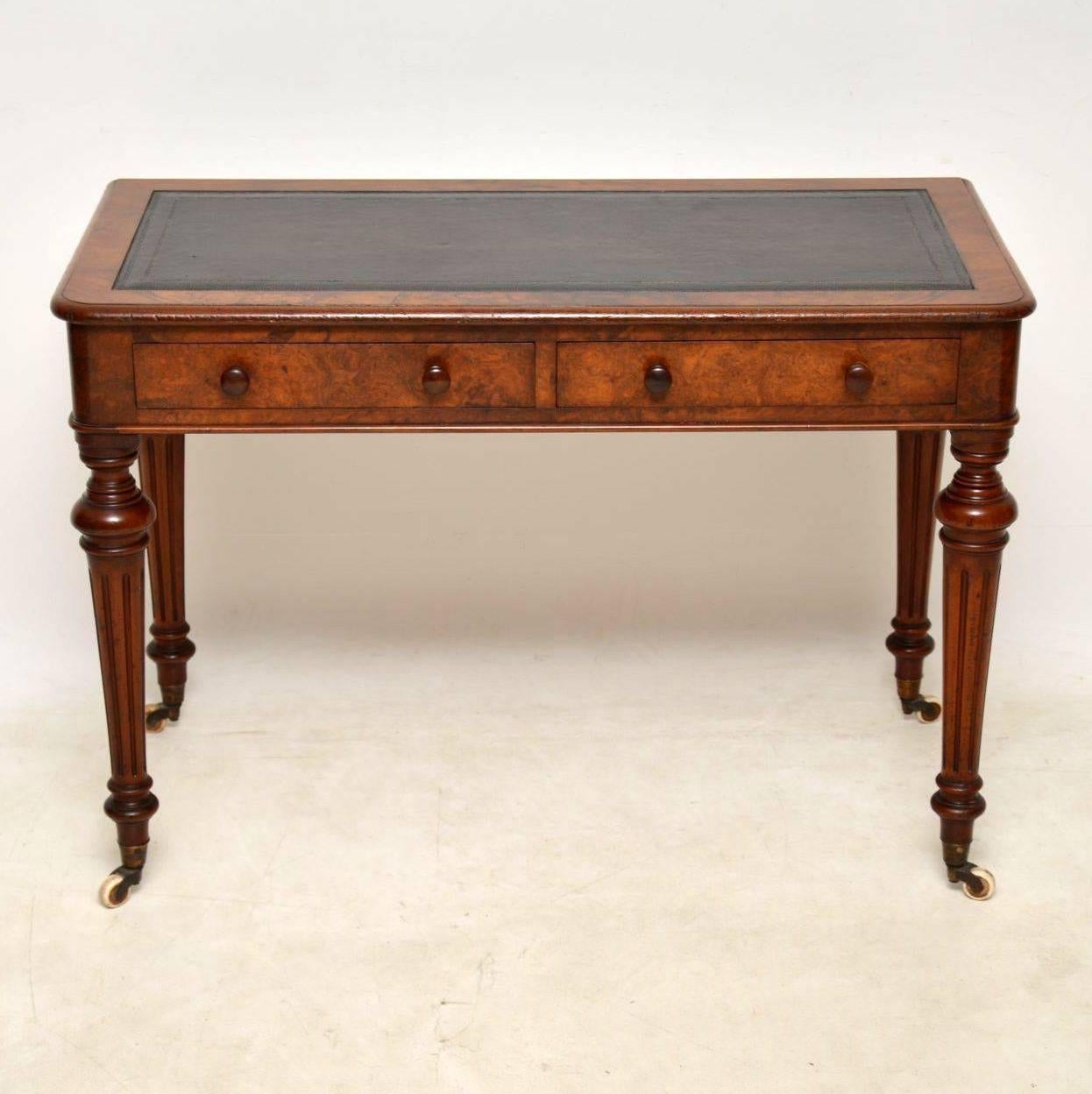 Antique early Victorian burr walnut writing table in good condition and with plenty of character. It has a faded blackish brown tooled leather writing surface. The top, front and sides are all burr walnut, while the turned fluted legs are solid