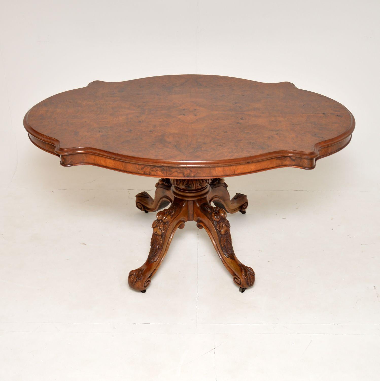 A magnificent antique Victorian burr walnut dining table, with a wonderful shape & bold carvings. This was made in England, it dates from around the 1860-1870 period.

It is of amazing quality, with a gorgeous burr walnut top with serpentine edges,