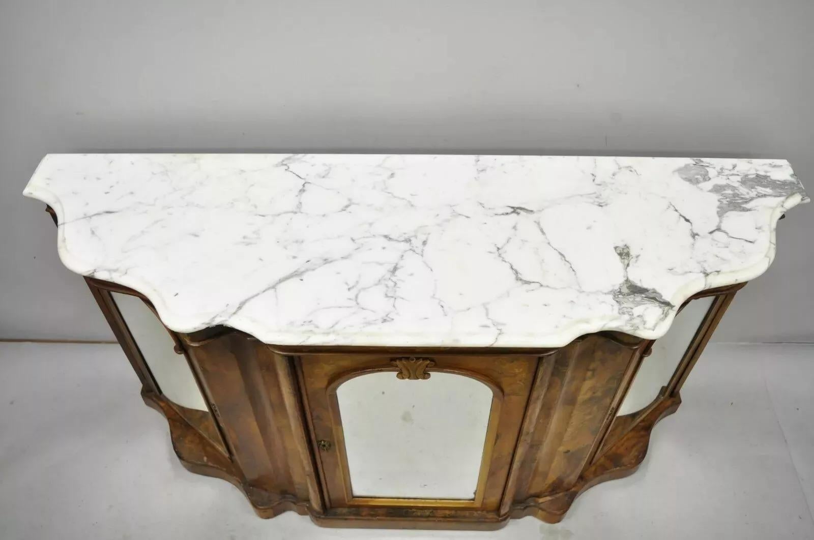 Ancienne crédence victorienne en ronce de noyer à plateau en marbre serpentin. L'objet présente un plateau en marbre façonné, une façade en miroir, un beau grain de bois, des détails joliment sculptés, 3 portes battantes, sans clé, mais