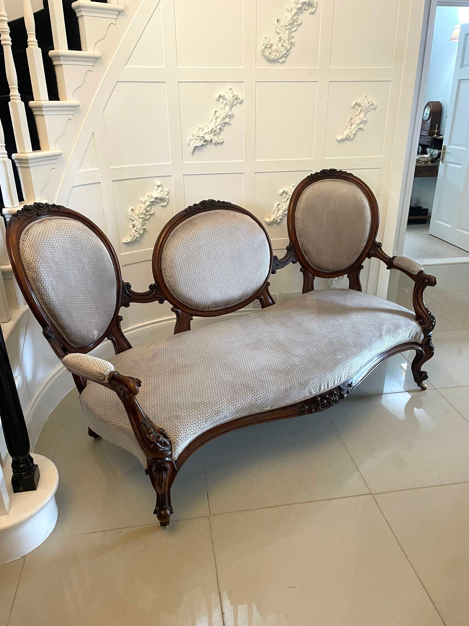 Antico divano vittoriano con schienale a cammeo intagliato in noce con tre schienali a cammeo con intagli di qualità sui piani uniti da stecche sagomate intagliate. Eleganti braccioli aperti sagomati intagliati, ringhiera anteriore in noce