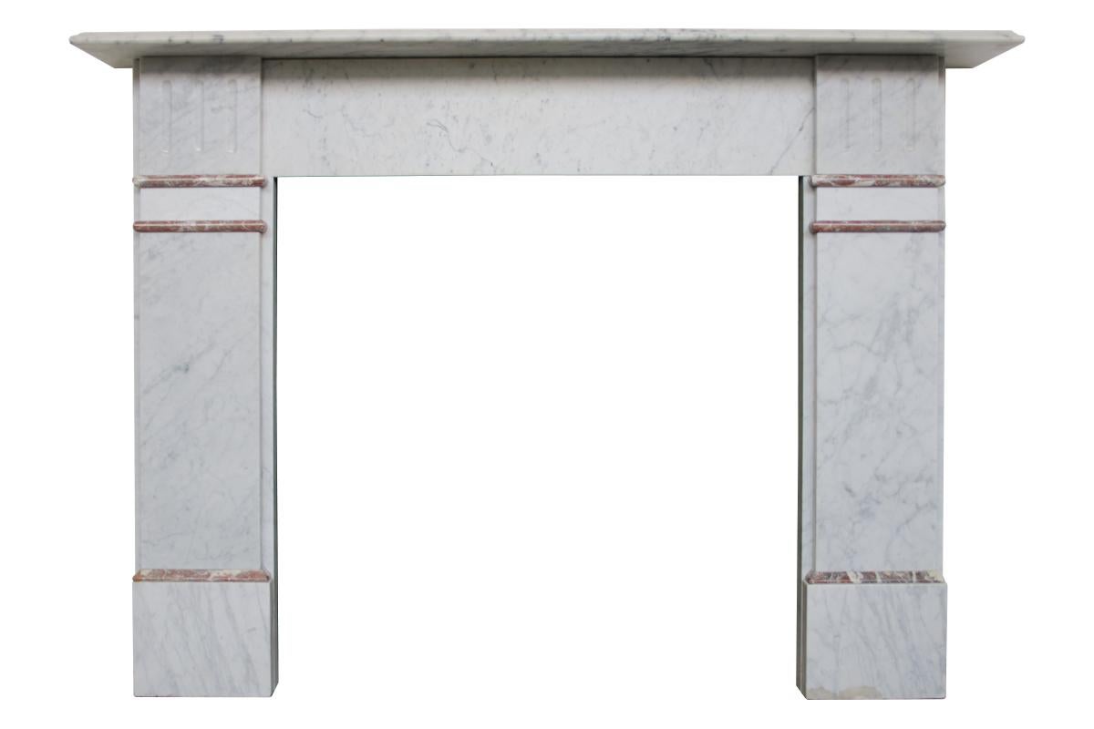 Antique Victorian Carrara marble fireplace surround with an ogee moulded shelf supported by fluted capitals above rouge marble interruptions on top of plain jambs and square foot blocks. Circa 1880.

For detailed sizes please see the size diagram