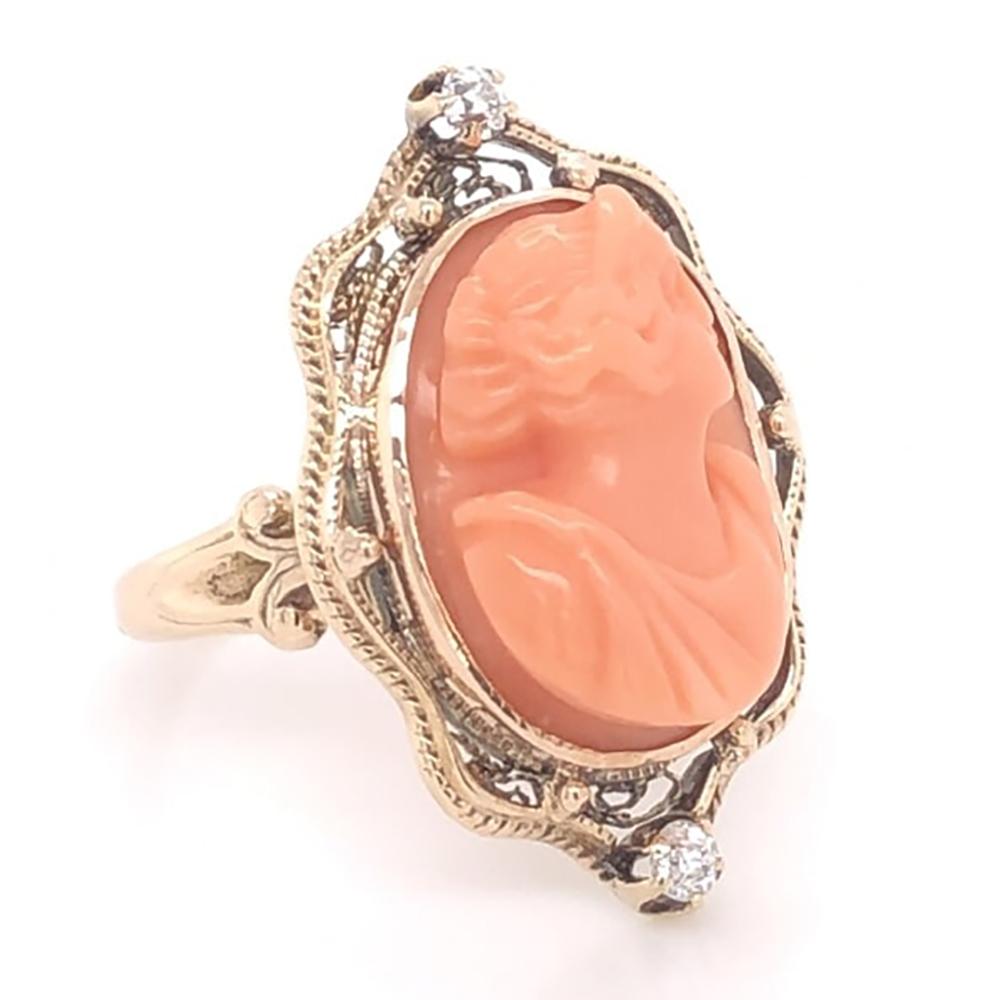 Elegant & finely detailed Antique Gold Ring set with a securely nestled carved Coral Cameo depicting a Beautiful Lady’s face, enhanced with old antique cut Diamonds, weighing approx. 0.12 total carat weight. Hand crafted in 10 Karat yellow Gold.