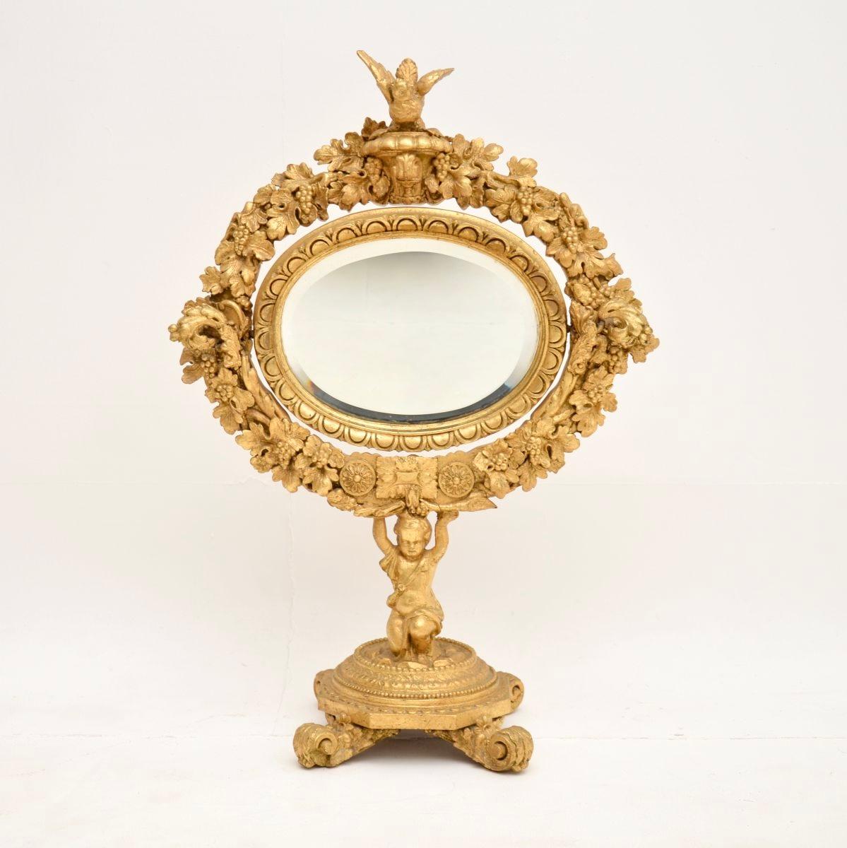 A stunning antique Victorian carved gilt wood vanity mirror, made in England and dating from around the 1850-1870 period.

It is of superb quality and is an impressive size, it is beautifully carved with intricate details throughout. The oval mirror