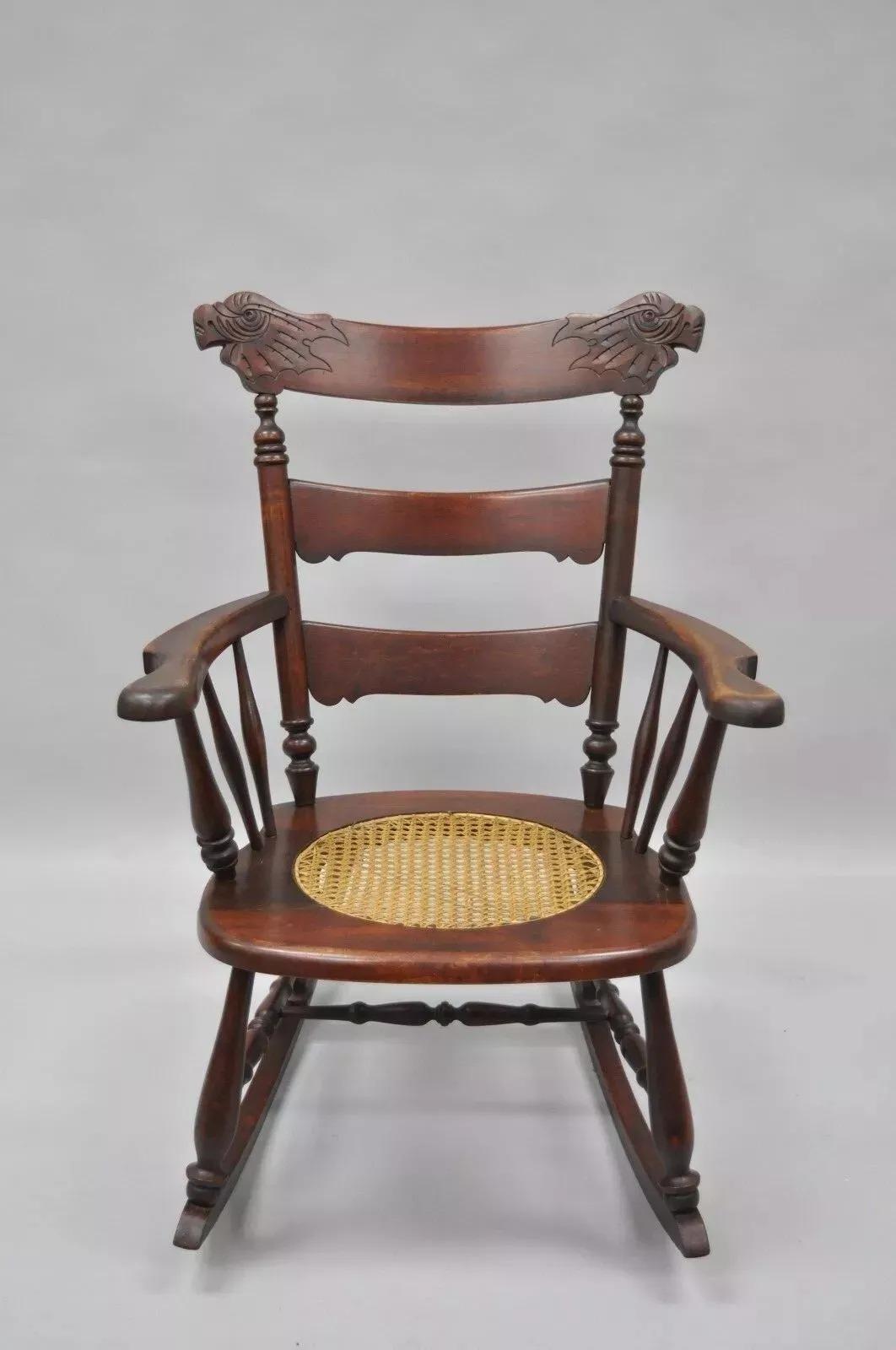 Antique Victorian Carved Mahogany Figural Eagle Cane Seat Rocker Rocking Chair. Item features solid wood frame, bird carved figural backrest, round cane seat, ladder back, great antique chair. Circa Early 20th Century. Measurements: 35