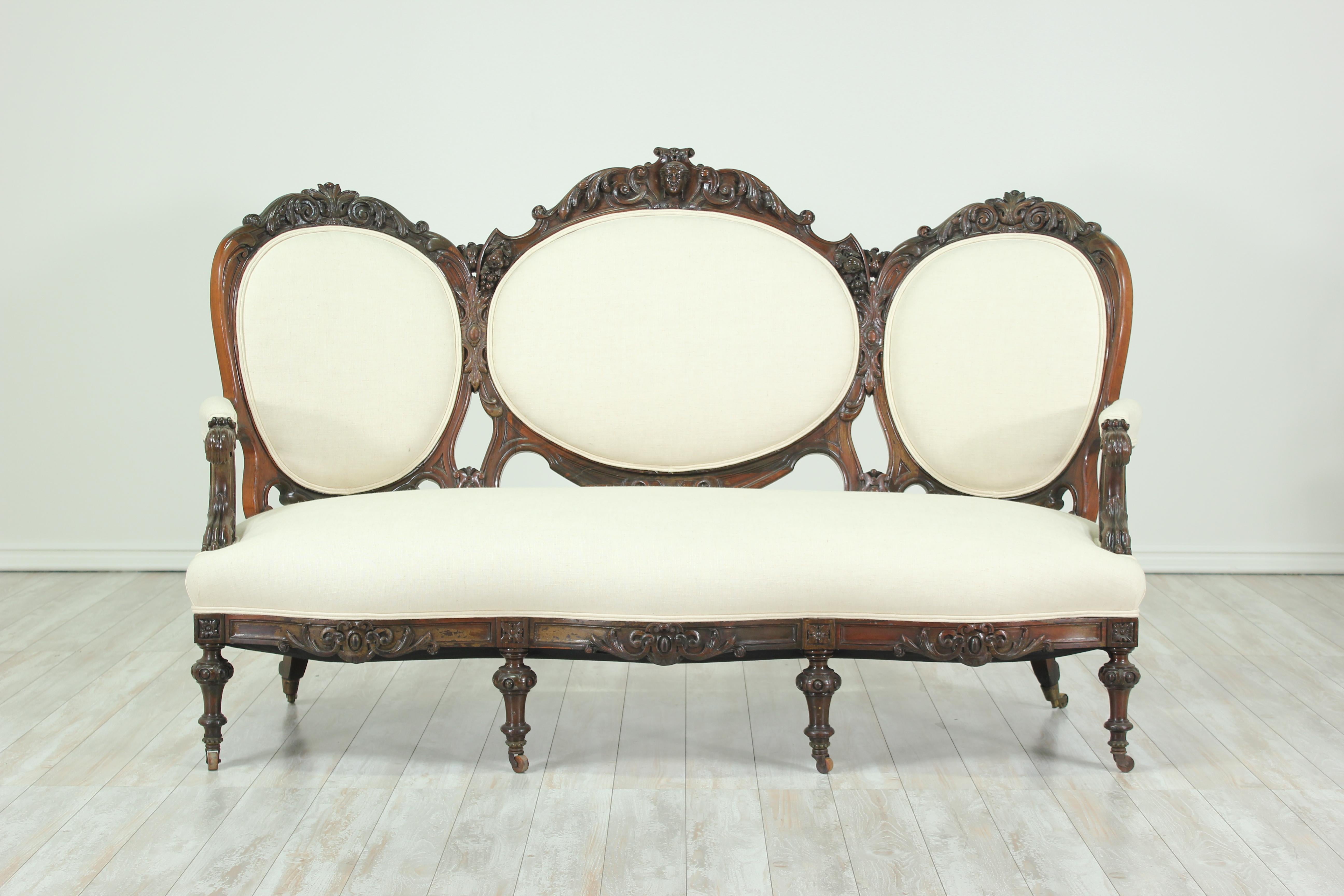 Beautifully carved and shapely mahogany 1930s Victorian-style sofa. Newly upholstered in a quality linen textile.. The sofa is sturdy and ready for years of use and enjoyment.