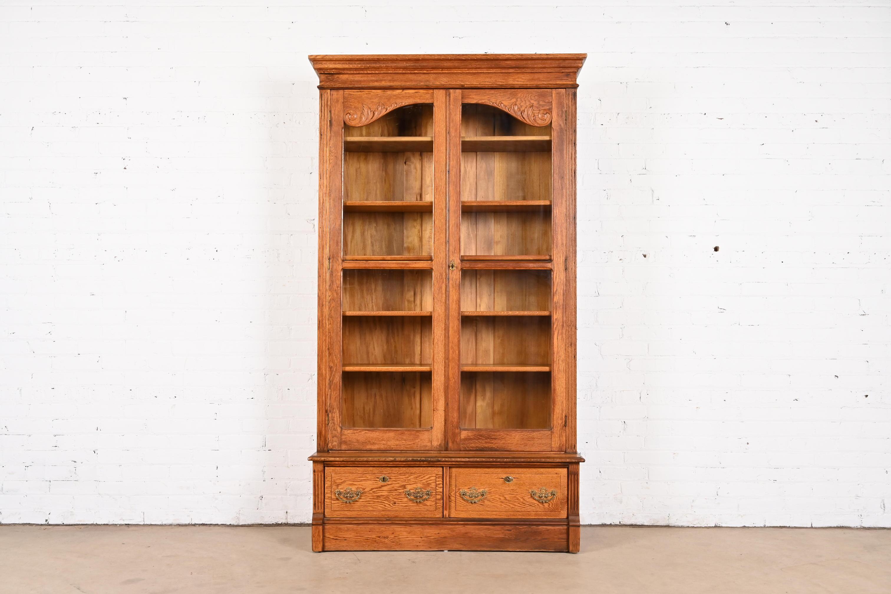 A gorgeous antique Late Victorian or Arts & Crafts bookcase

USA, Circa 1900

Carved oak, with glass front doors, and brass hardware. Cabinet doors and drawers lock. Two keys included.

Measures: 44.5
