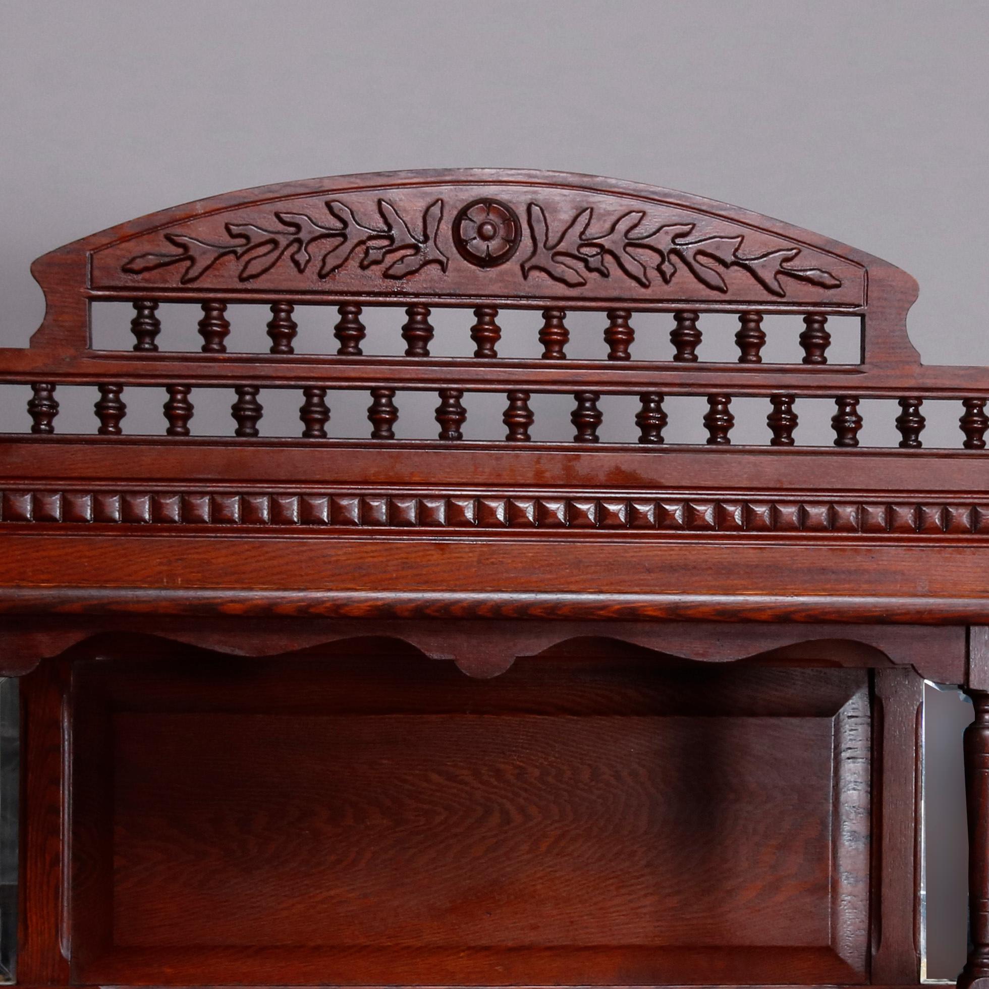 An antique stick and ball form Victorian carved oak bookcase offers foliate carved crest surmounting display shelf with mirrored back over enclosed bookcase having double glass doors, circa 1910.

***DELIVERY NOTICE – Due to COVID-19 we have