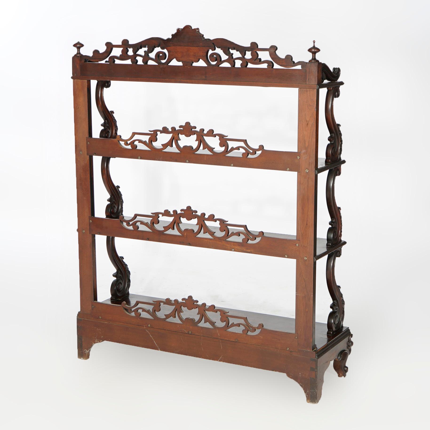 An antique open bookshelf offers rosewood construction having tiered shelving with carved foliate and scroll pierced backsplashes, scroll form supports and raised on cabriole legs, c1880.

Measures- 49.5''H x 38.75''W x 12.5''D.

Catalogue Note: Ask