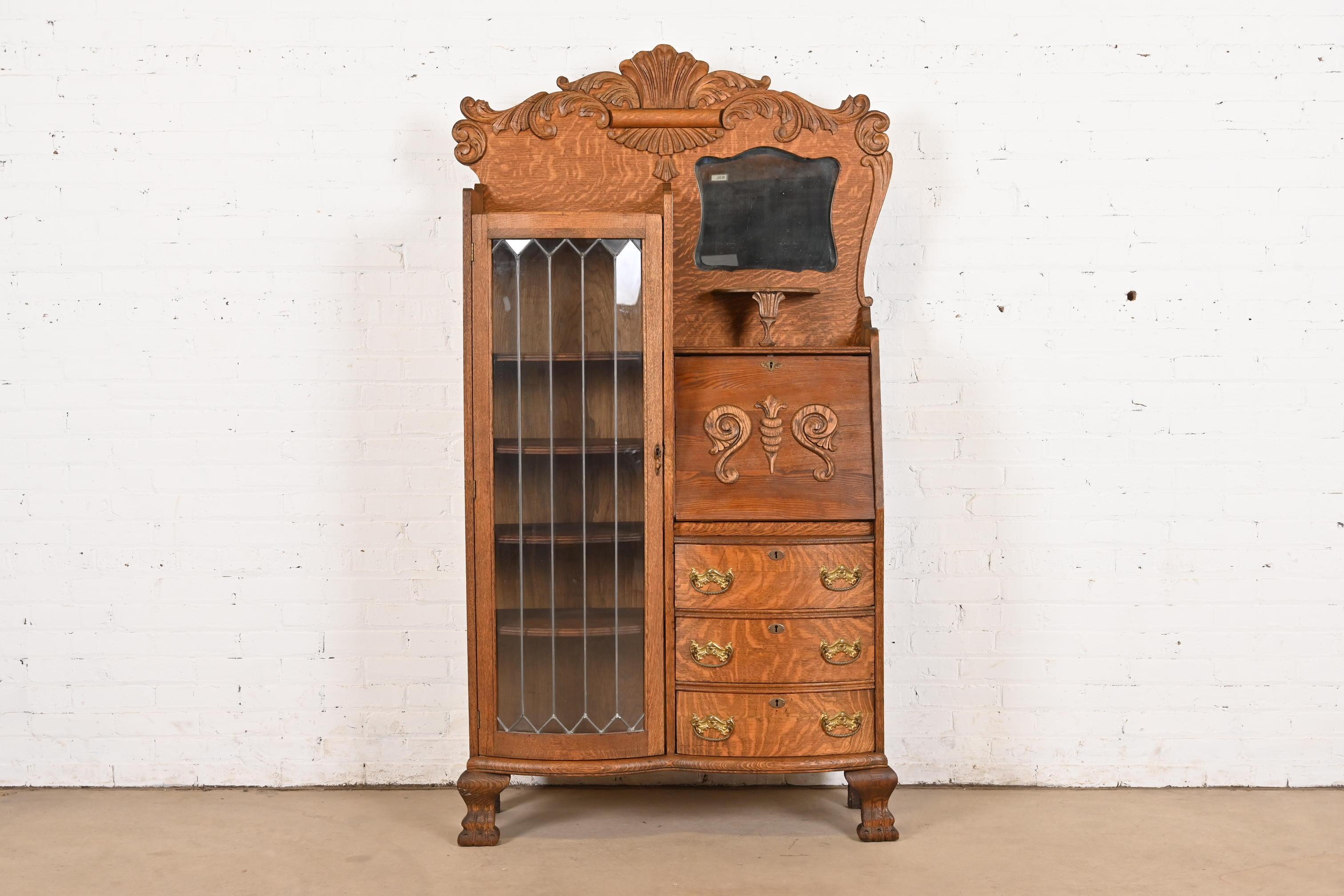 A gorgeous Victorian side-by-side drop front secretary desk and bookcase or display cabinet

In the manner of R.J. Horner & Co.

USA, Circa 1900

Carved tiger oak, with mullioned leaded glass door, and original brass hardware.

Measures: 39