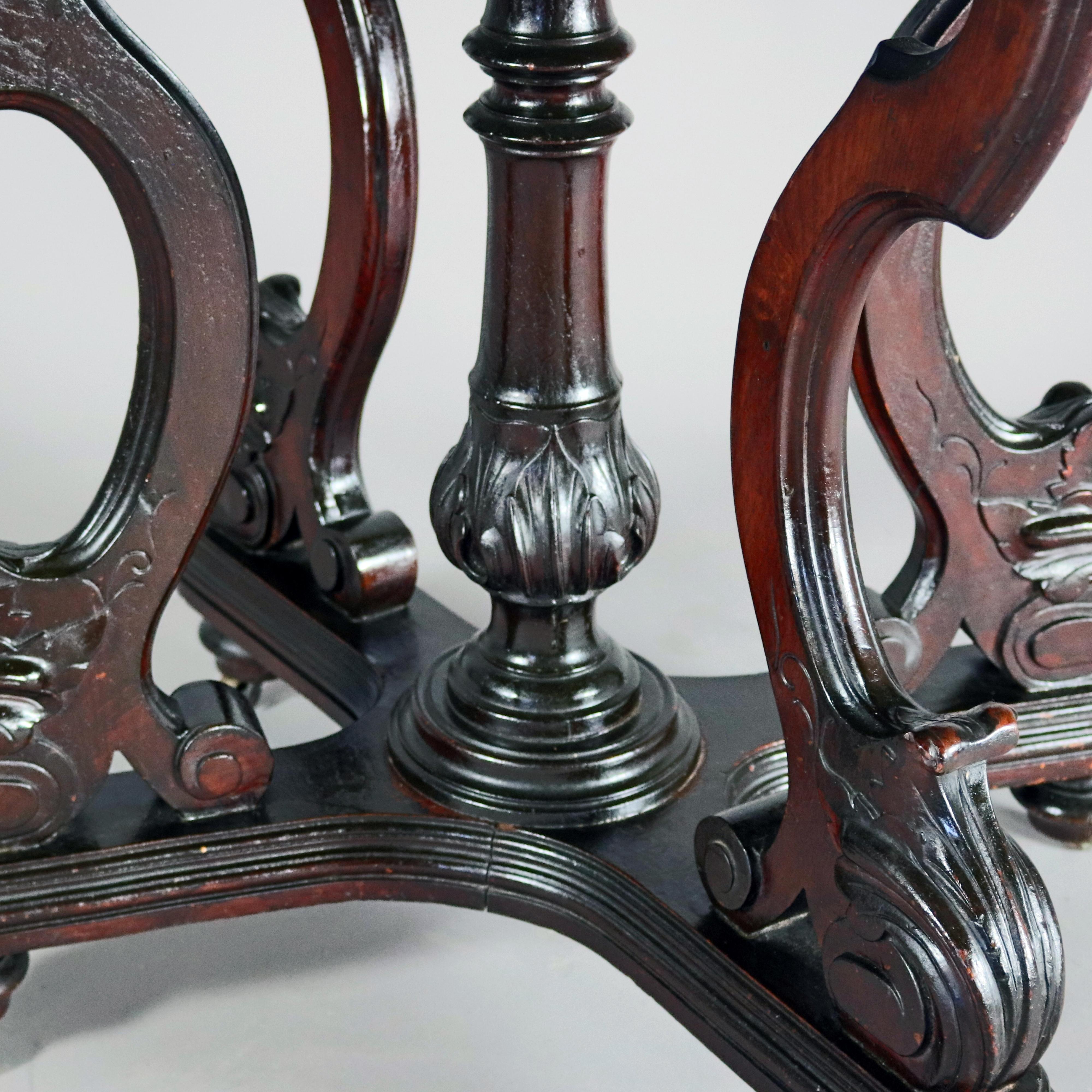 An antique Victorian center table features beveled marble top surmounting walnut base with carved scroll and foliate legs and center turned and acanthus carved column
 seated on stepped x-form base with casters, circa 1880.

Measures - 29.75