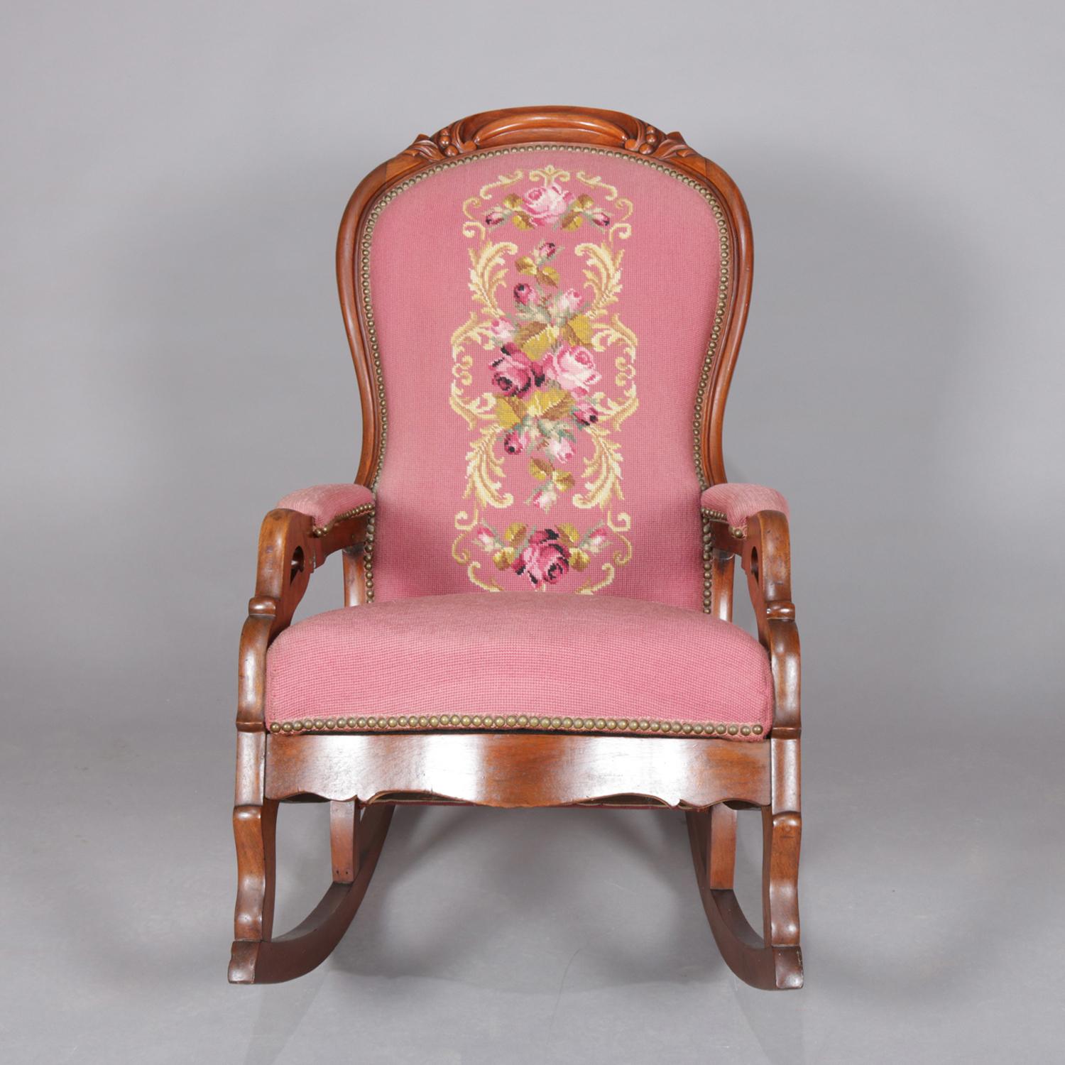 An antique Victorian Lincoln rocking chair features carved walnut frame having balloon back with carved scroll and foliate crest, cut out arms and shaped skirt, needlepoint upholstery with rose garden design, circa 1890

Measures: 37.5