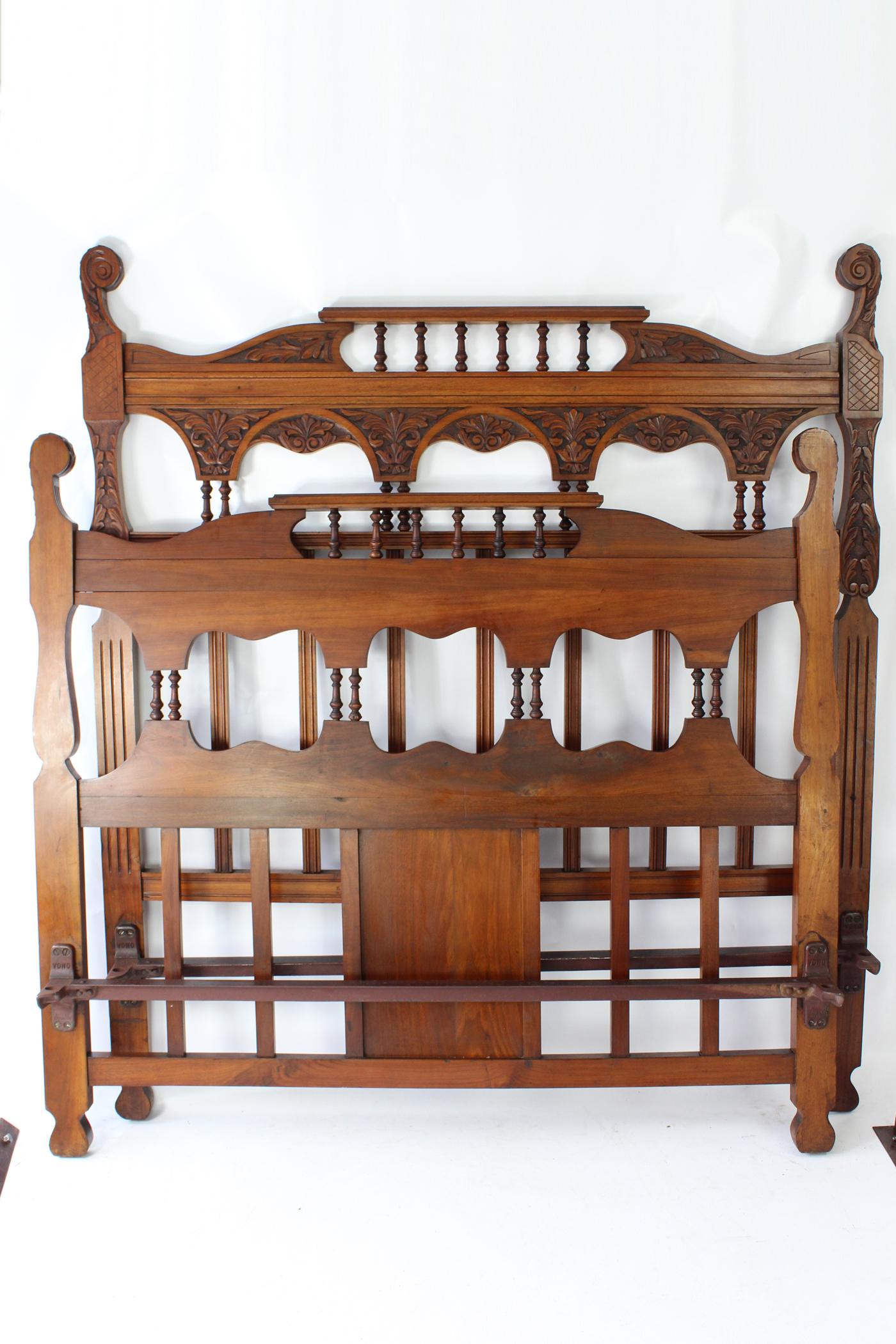 A truly magnificent antique Victorian carved walnut double bed dating from circa 1895. In a richly figured walnut, with attractive foliate carving throughout. Featuring carved top rails with turned twin pilaster supports and vertical slats, the