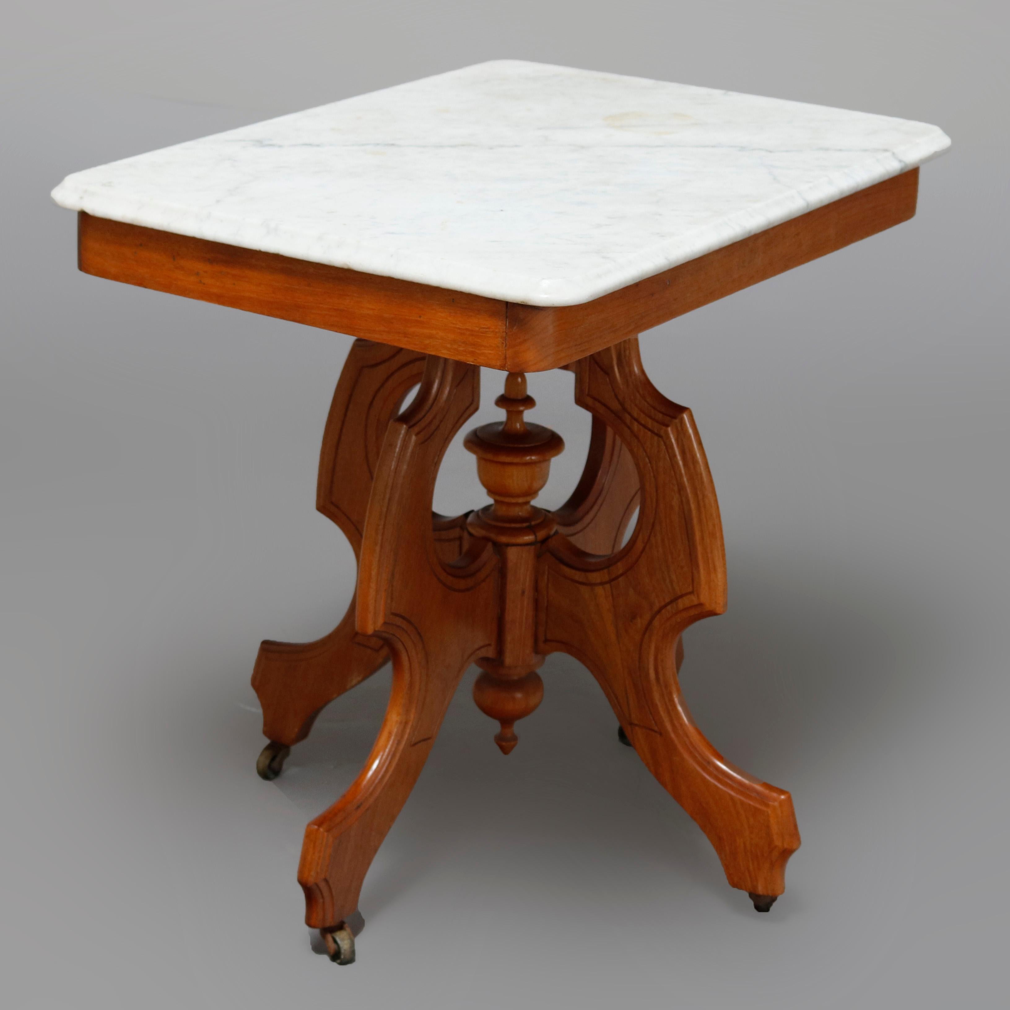 An antique Victorian Eastlake side table offers a beveled rectangular marble top surmounting carved walnut frame having skirt raised on shaped legs with central turned urn form and drop finial, circa 1880


Measures: 23