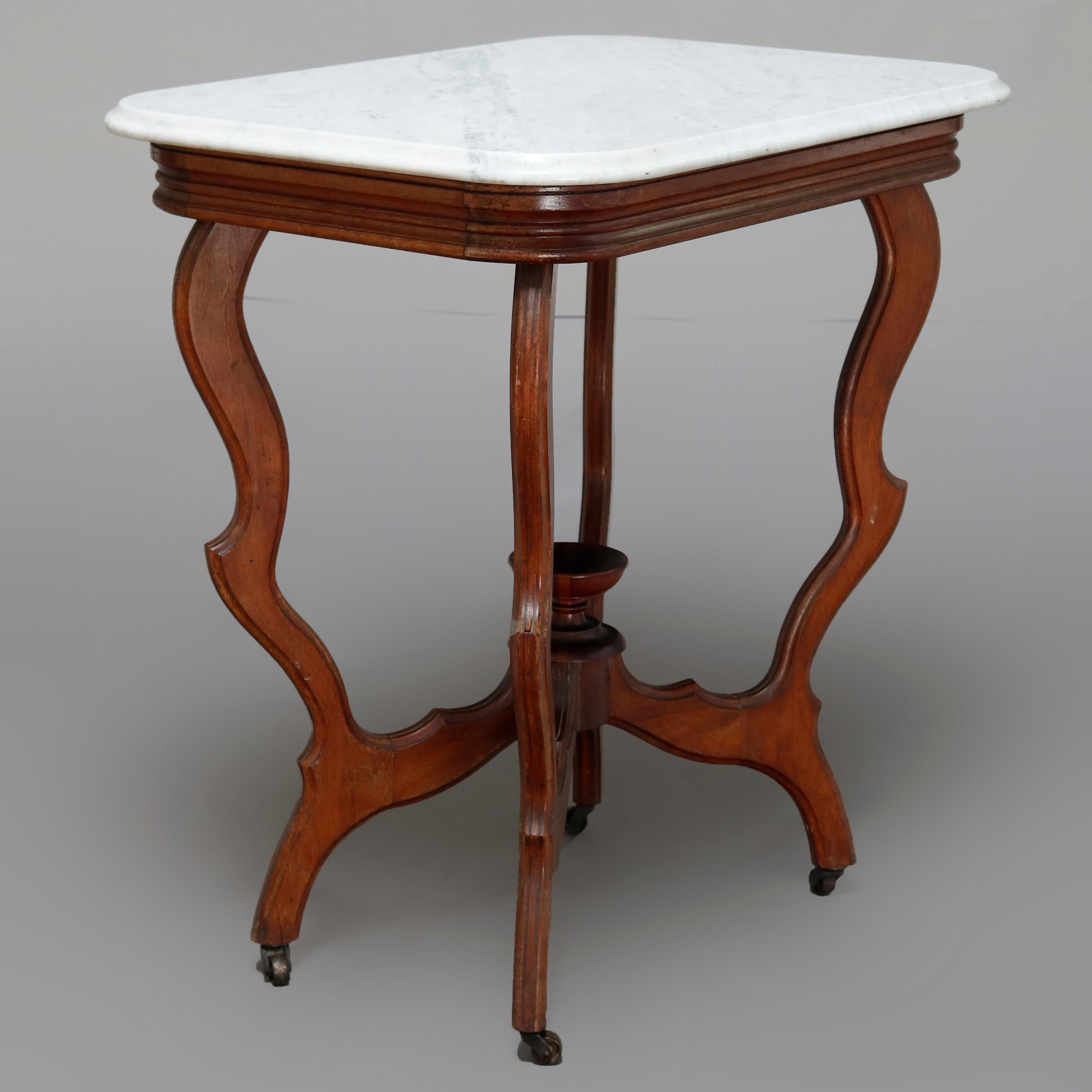 An antique Victorian Eastlake side table offers a beveled rectangular marble top surmounting carved walnut frame having stepped skirt and raised on s-scroll legs with central urn form finial, circa 1880.


Measures: 29