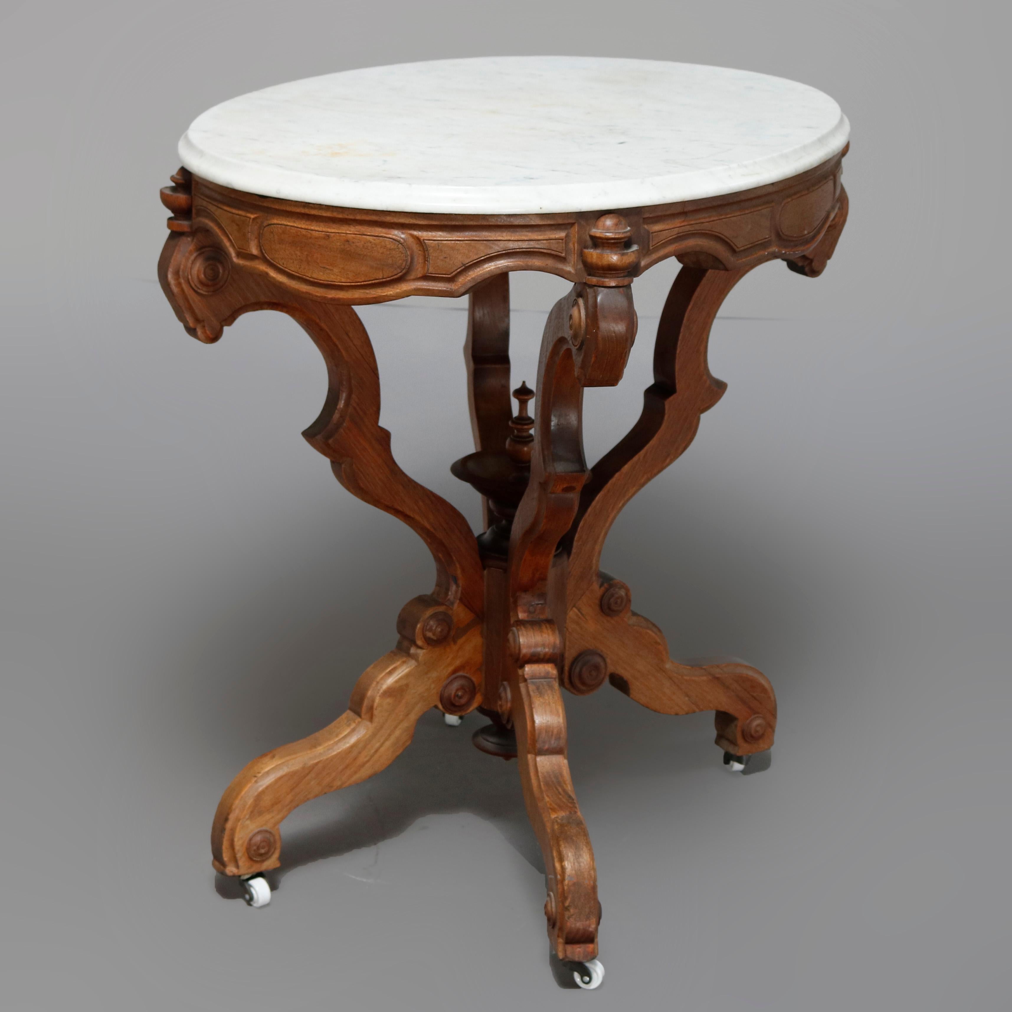 An antique Victorian Eastlake side table offers a beveled oval marble top surmounting carved walnut frame having paneled skirt raised on s-scroll legs and central urn form finial, circa 1880

***DELIVERY NOTICE – Due to COVID-19 we have employed