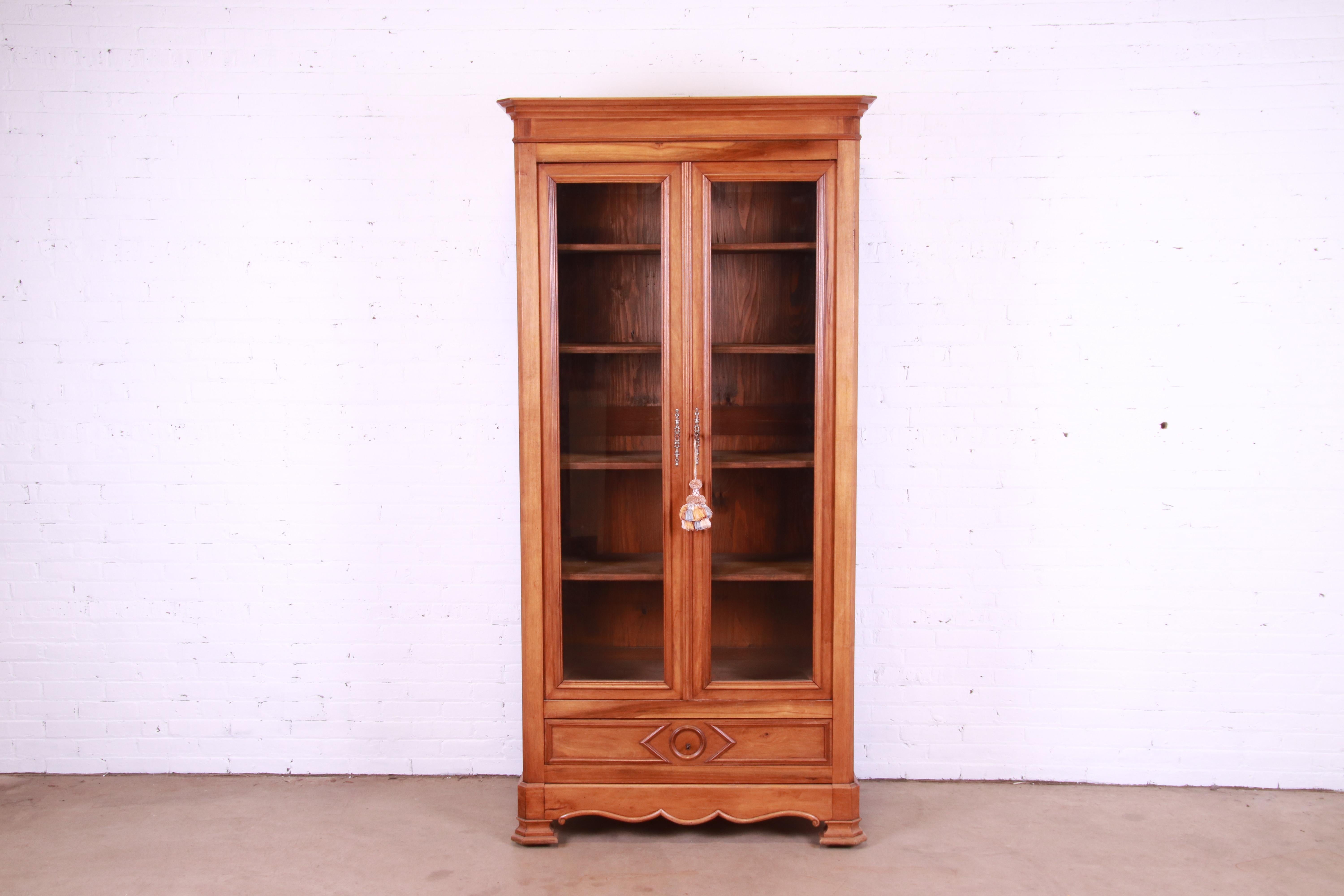 A gorgeous antique Victorian bookcase cabinet

USA, Circa 1890s

Carved solid walnut, with glass front doors and original brass hardware.

Measures: 43.5
