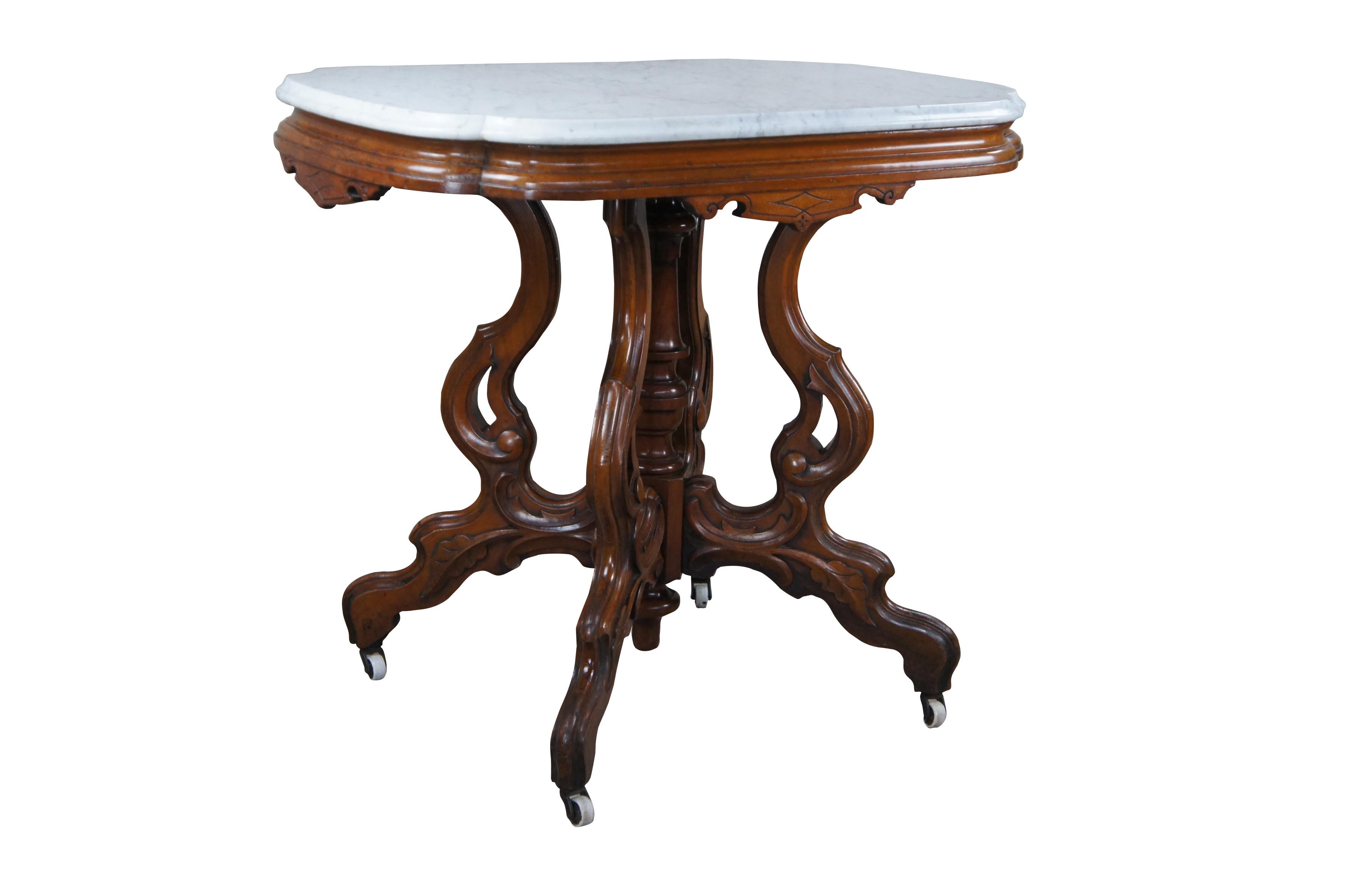 Antique Victorian Eastlake parlor table, circa 1880s.  Made from walnut featuring a rectangular / scalloped and beveled marble top with turned center support surrounded by four serpentine carved acanthus legs over castors.

Dimensions:
33